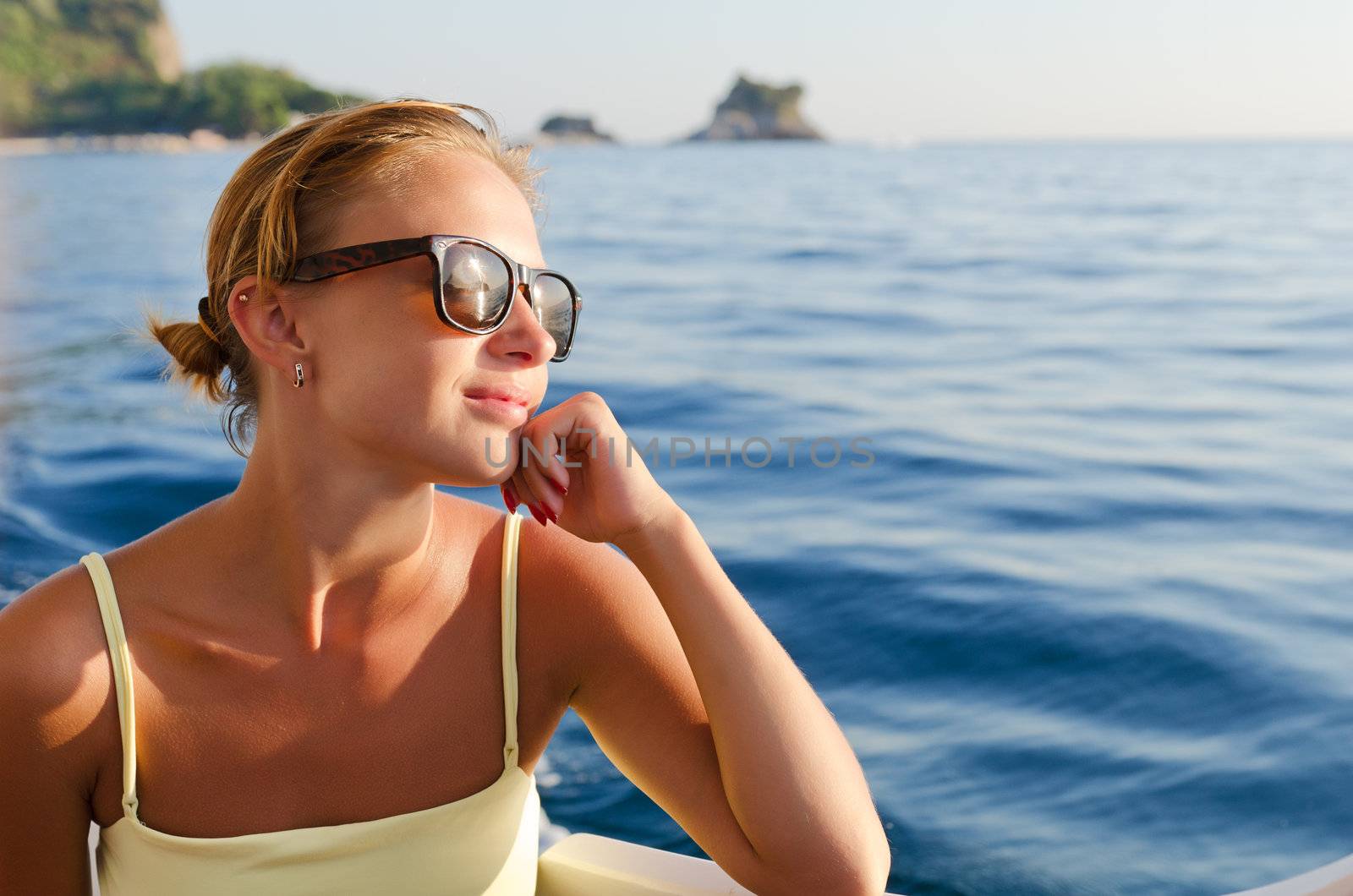 Beautiful red woman enjoying yacht cruise on a hot summer day