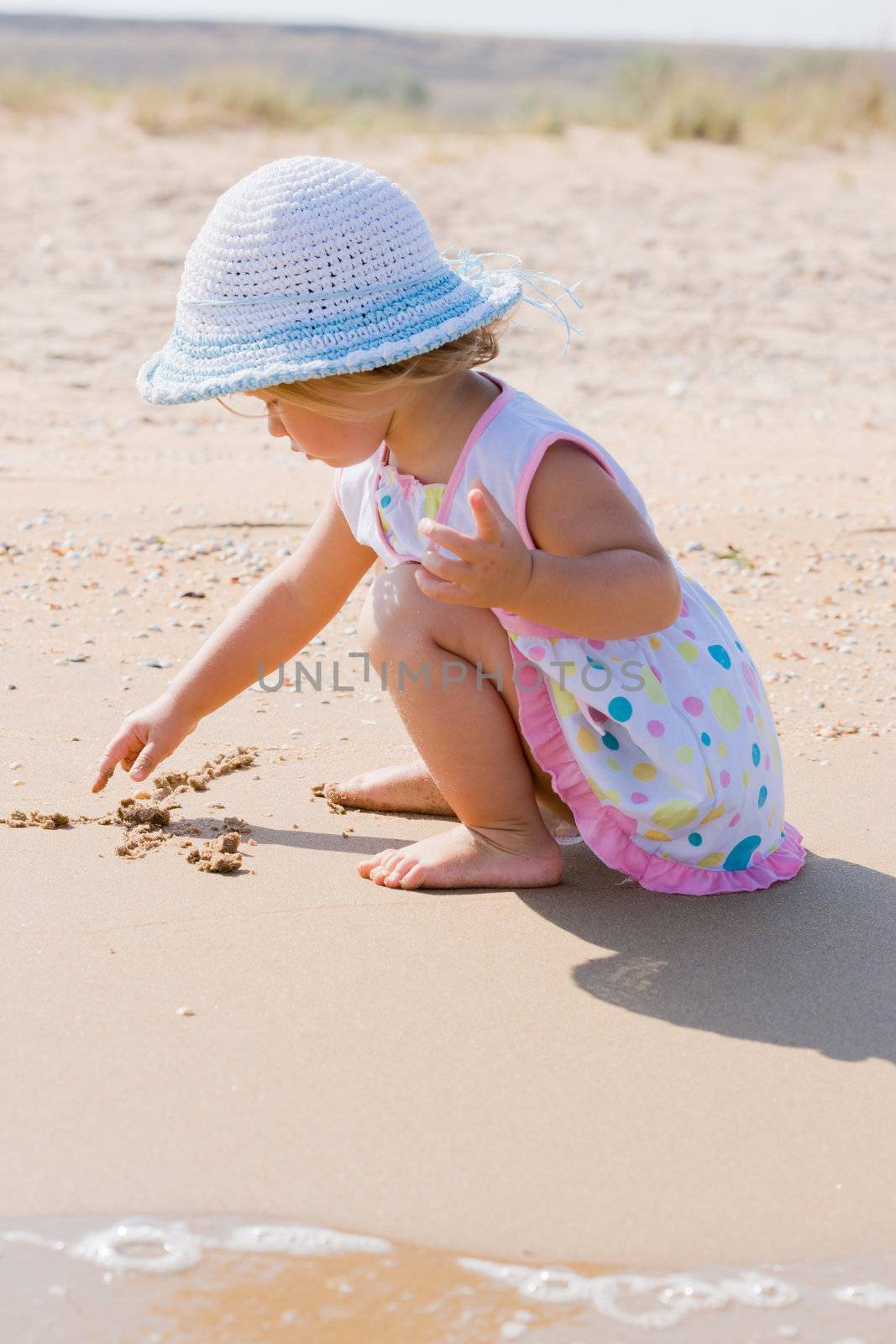 people series: little girl draw on the sand