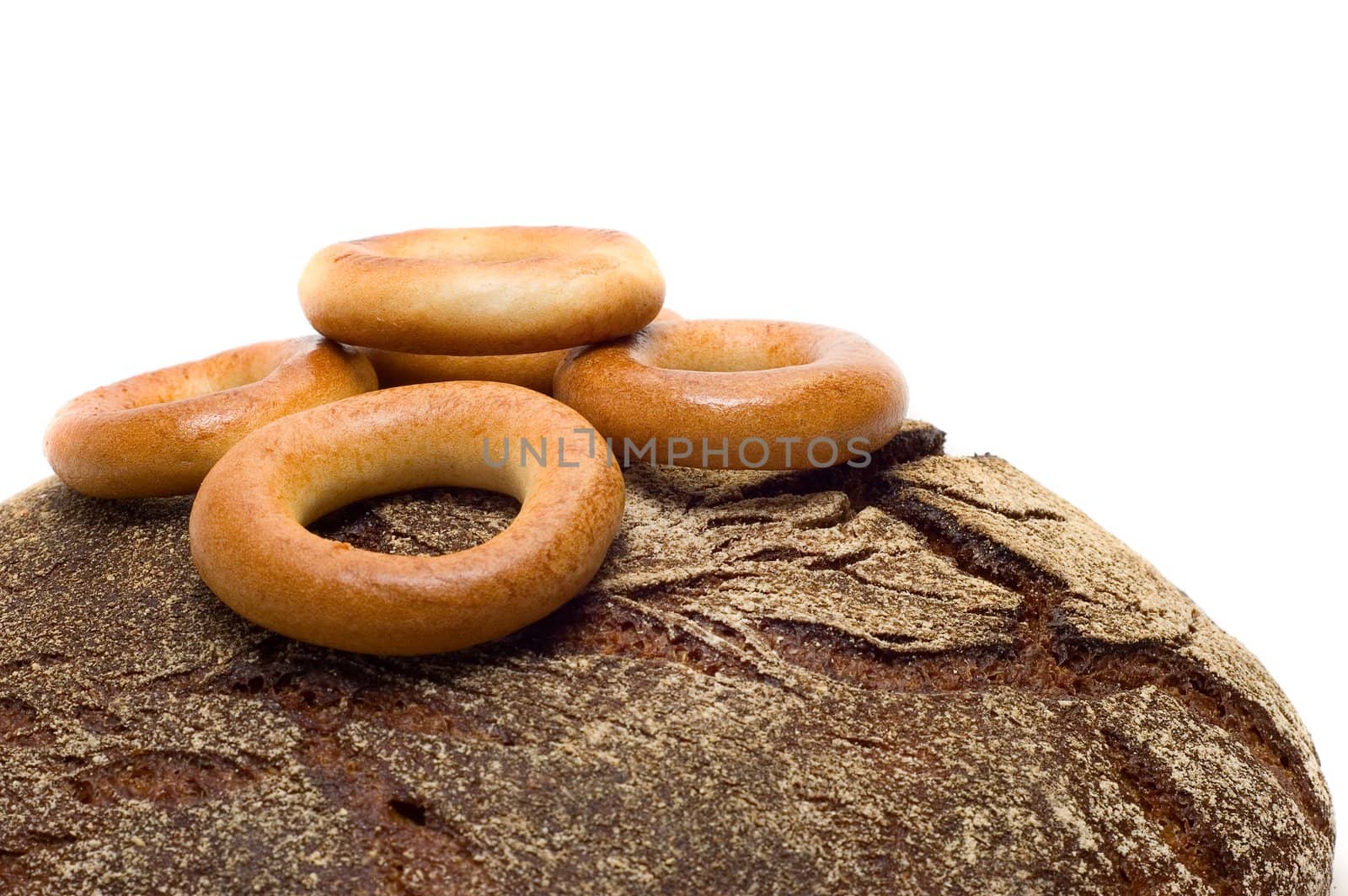 Loaf of bread and bread ring on white background