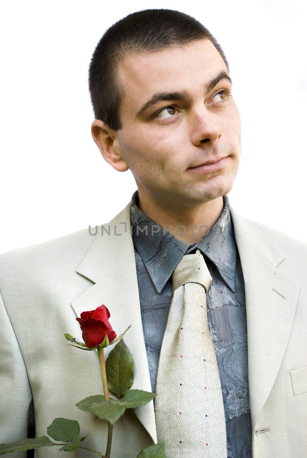 young romantic business man holding red rose in hand looking up