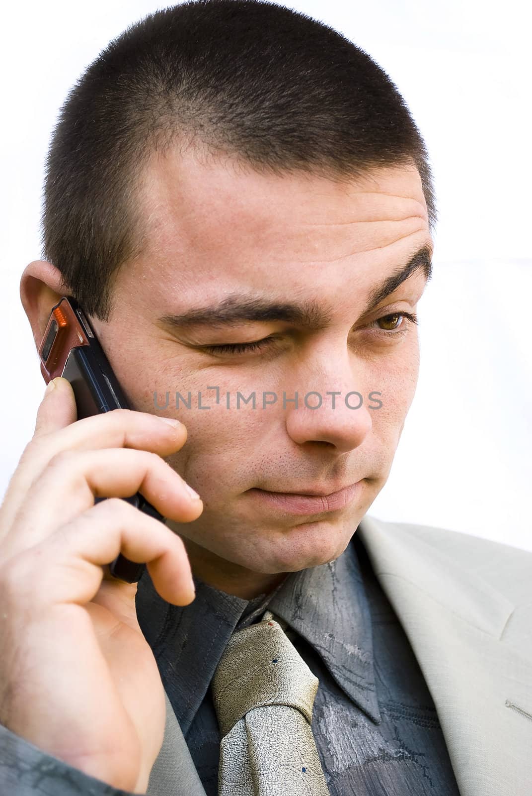 young handsome man talking on his mobile phone making not sure face