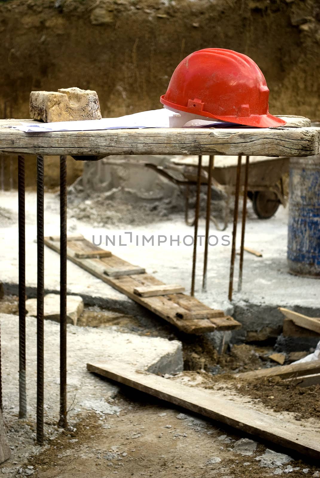 construction site red hard hat and project over wooden boards