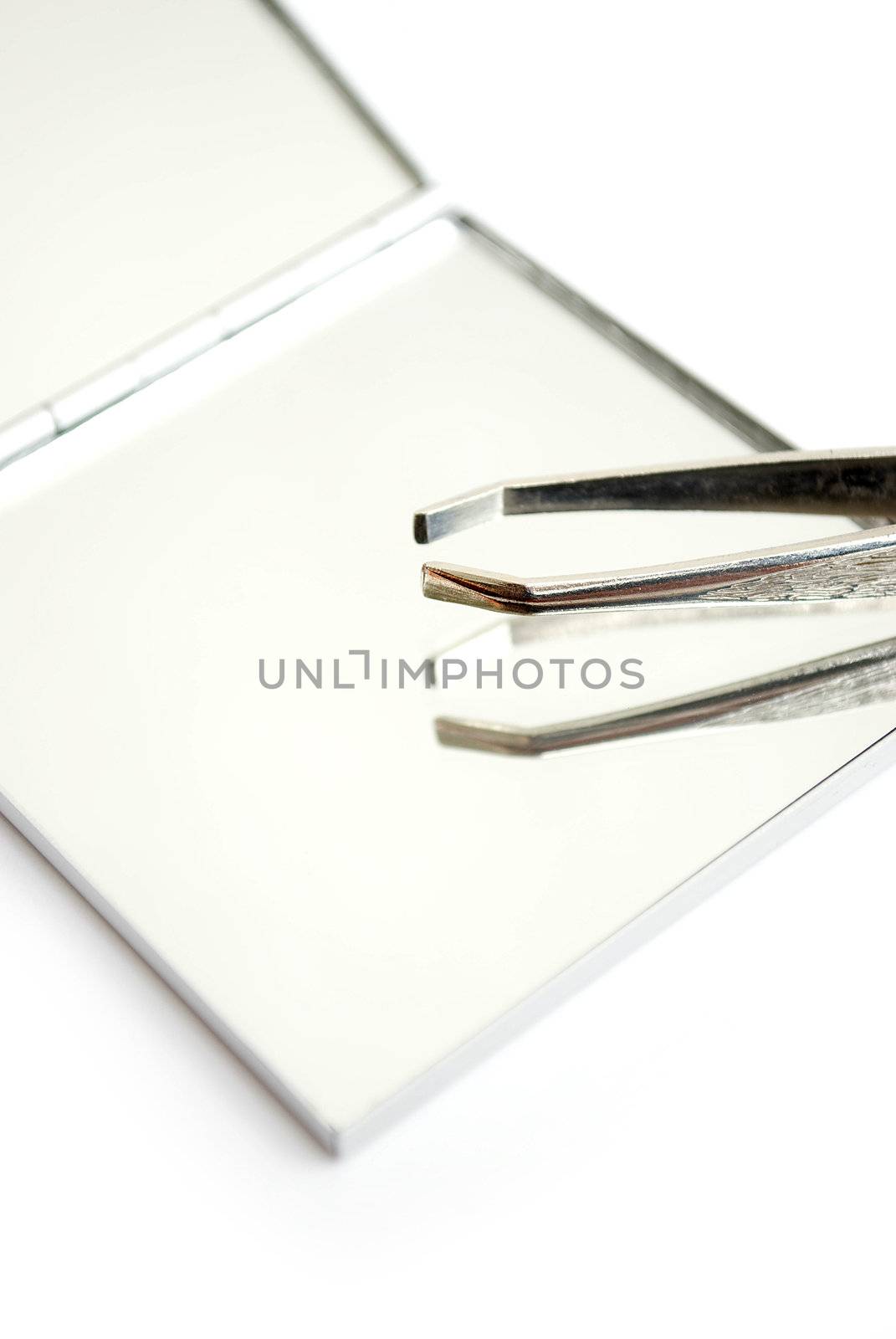 tweezers and mirror isolated on white