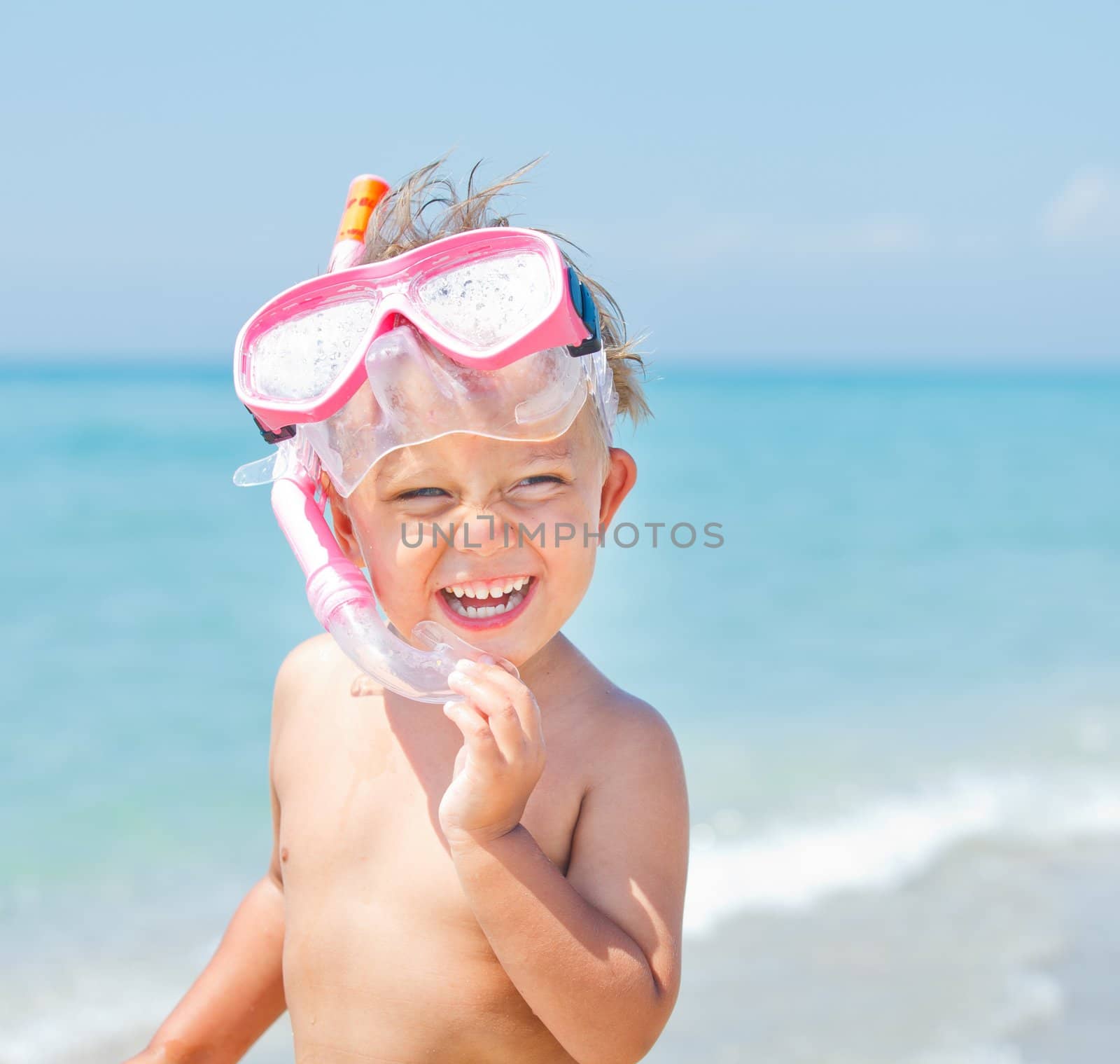 A cute little boy wearing a mask for diving background of the sea