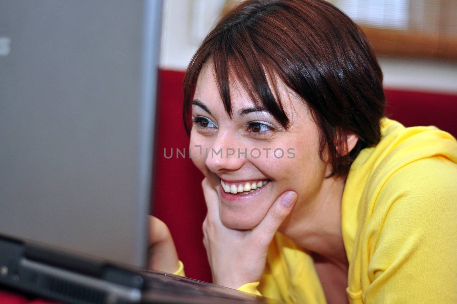 Portrait of happy young woman looking at the laptop at home