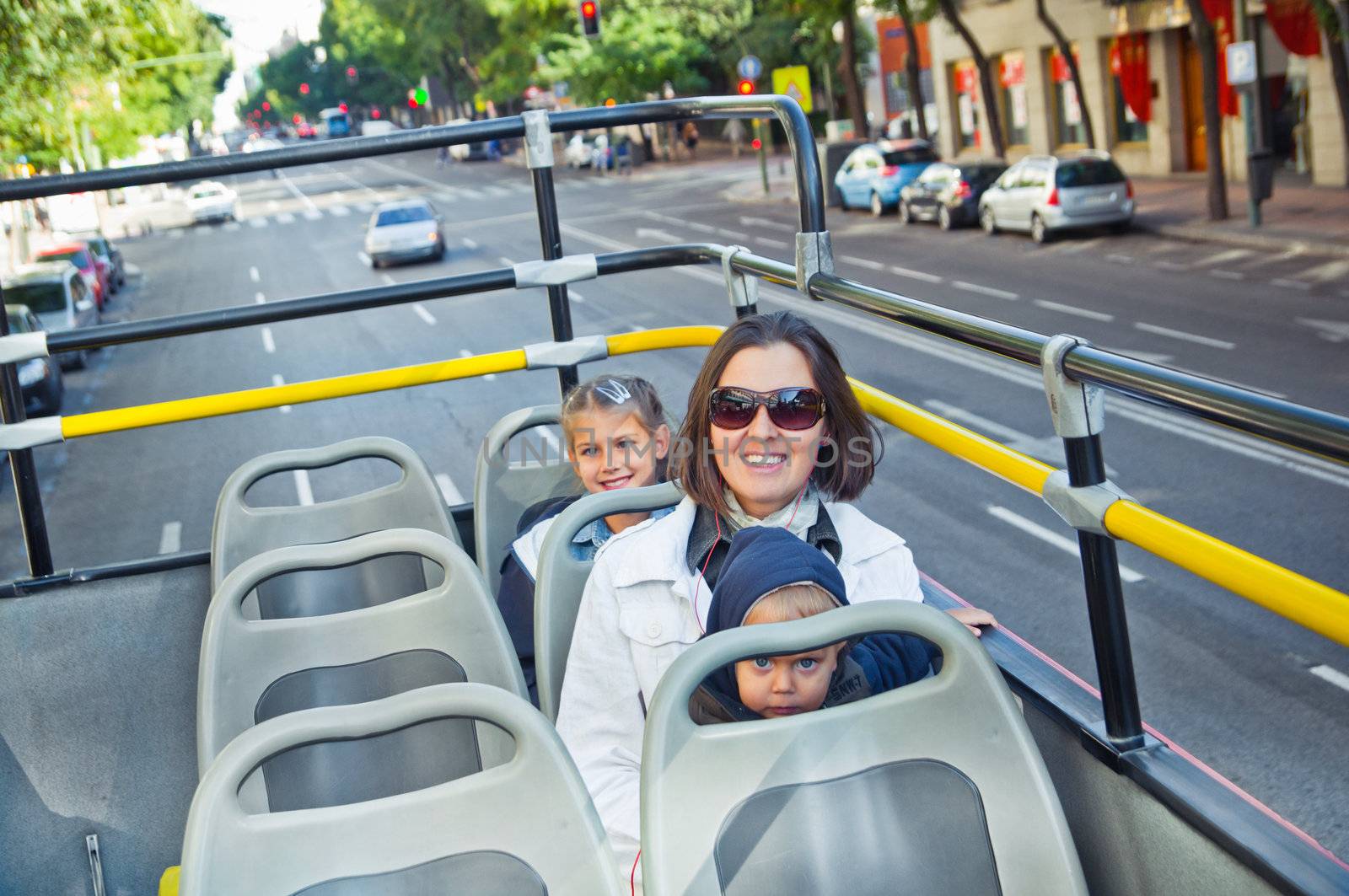 Young mother with children on an excursion in a bus. Madrid. Spane