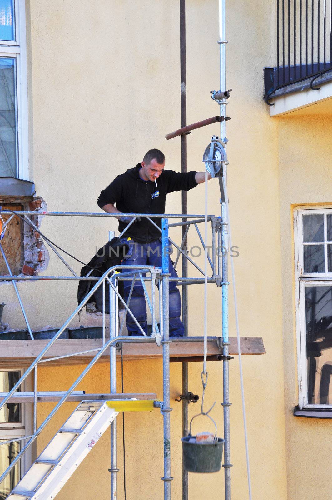 Balcony builder lowering a bucket with bricks to the ground in Stockholm, Sweden. Photo taken september 28 2011