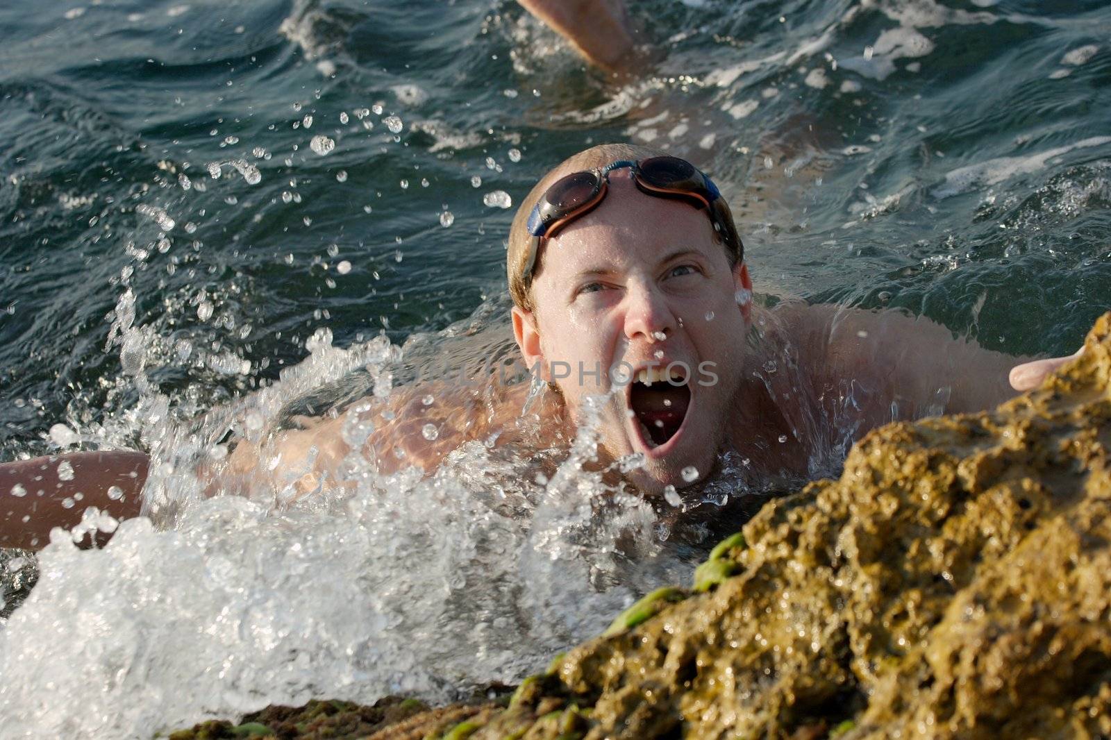 Young man swimming in the see grinning