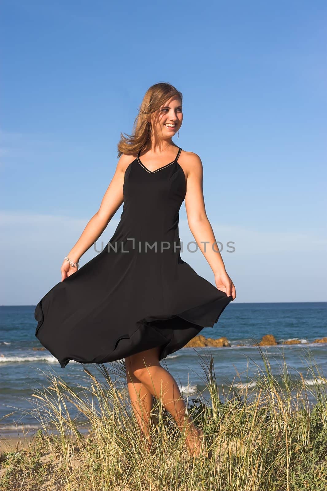 Young Teenage girl swirling her dress in the wind at the beach