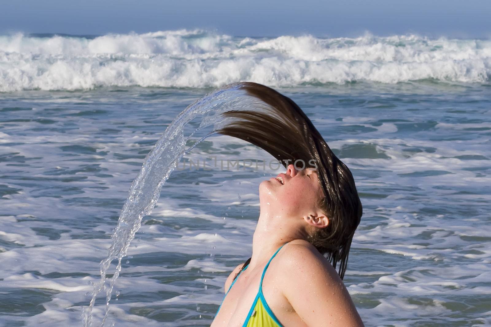 Bikini model fling her head back, with hair drenched in water
