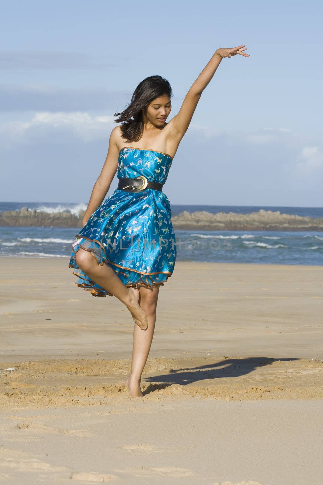 Girl in blue dress striking a ballerina poise