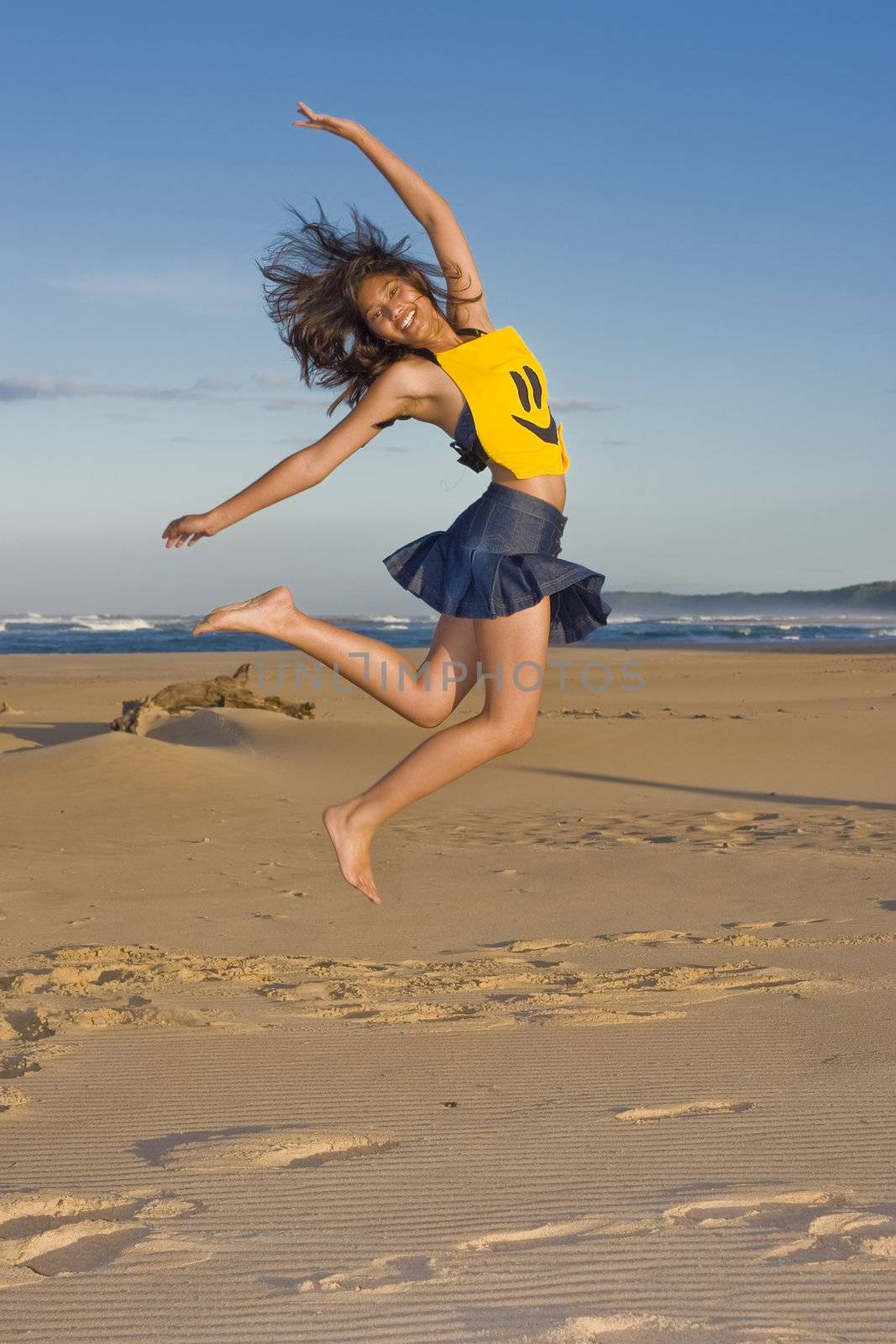 Girl with smily face top on jumping in the air
