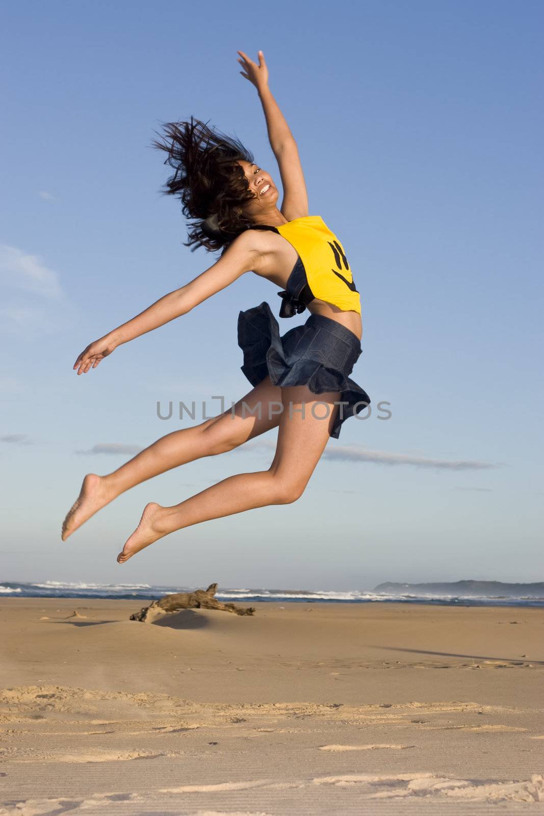 Girl with "happy Face" top on jumping in the air