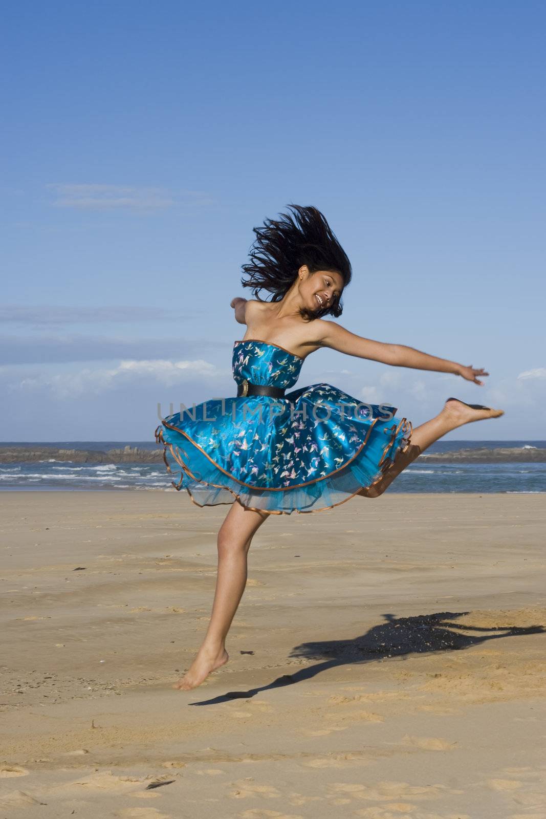Pretty girl jumping wearing a puffy blue dress