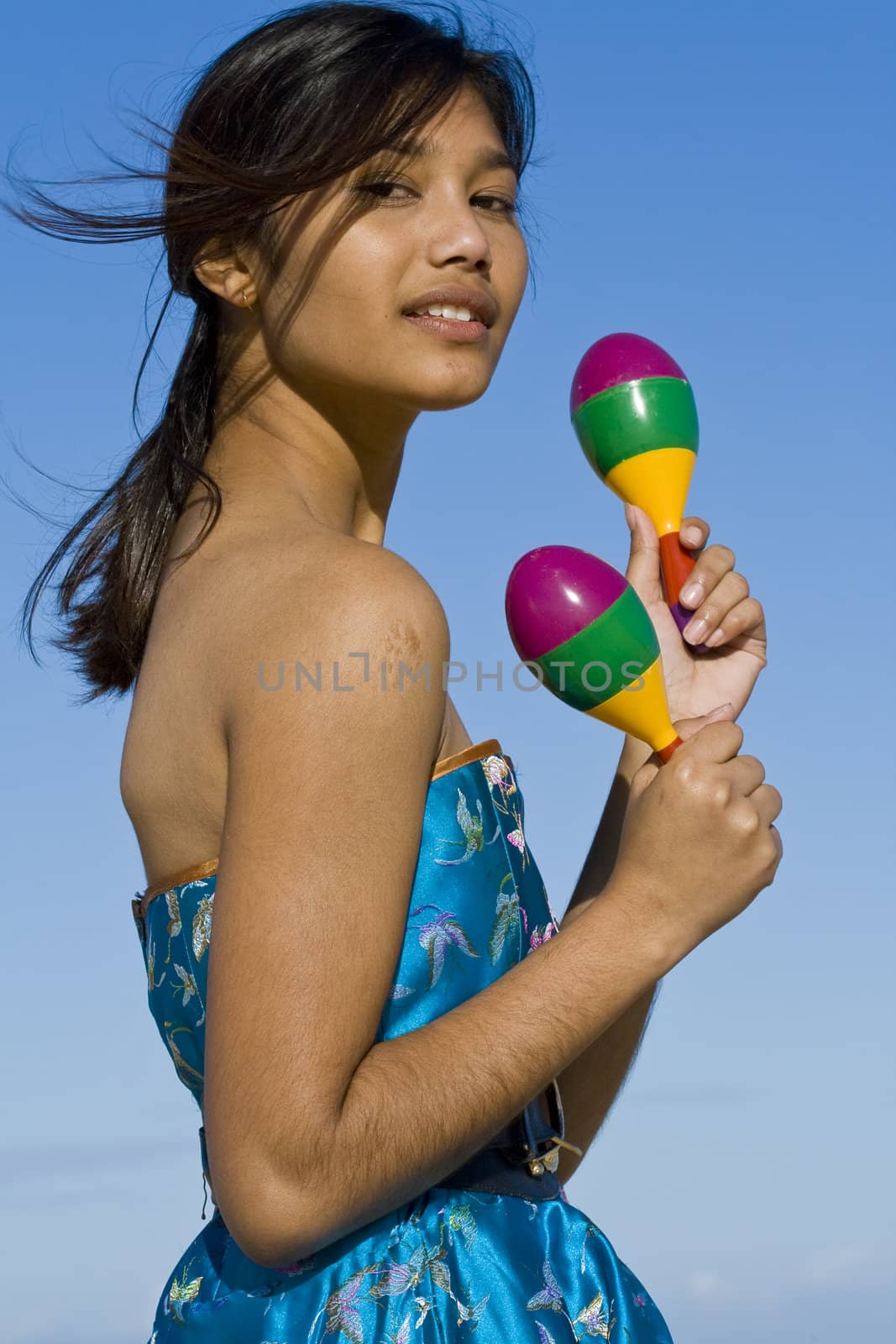 Girl in asian inspired dress with two colourful shakers