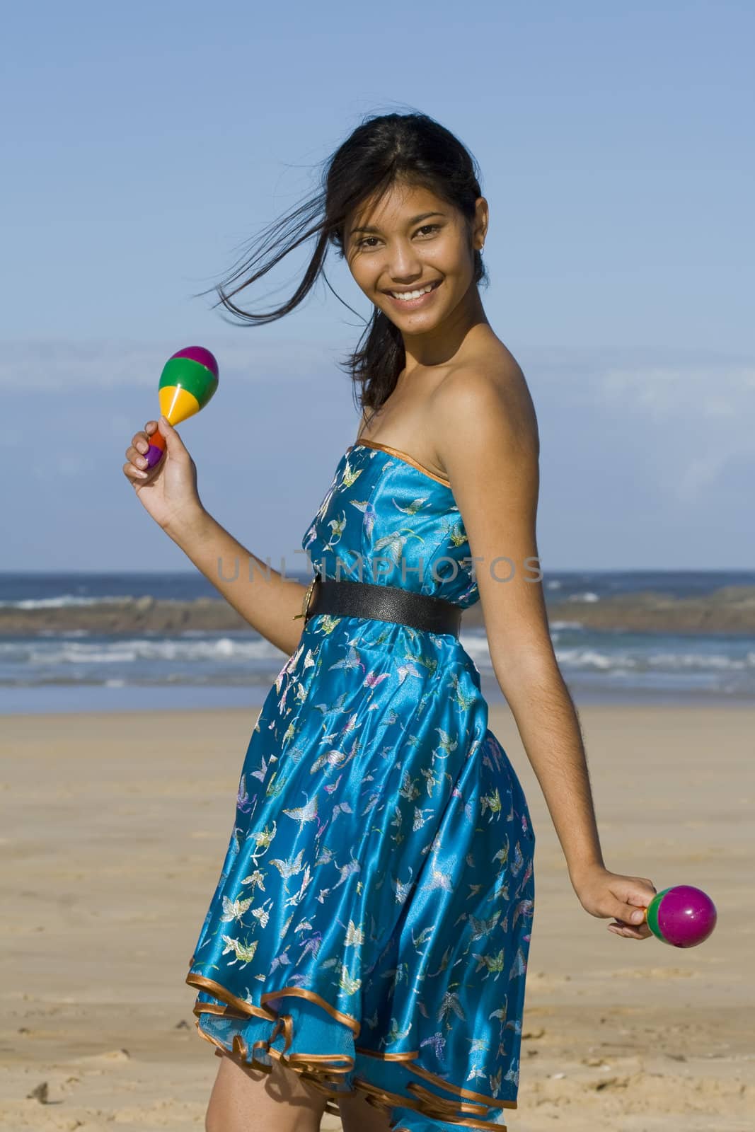 Girl in asian inspired dress with two colourful shakers