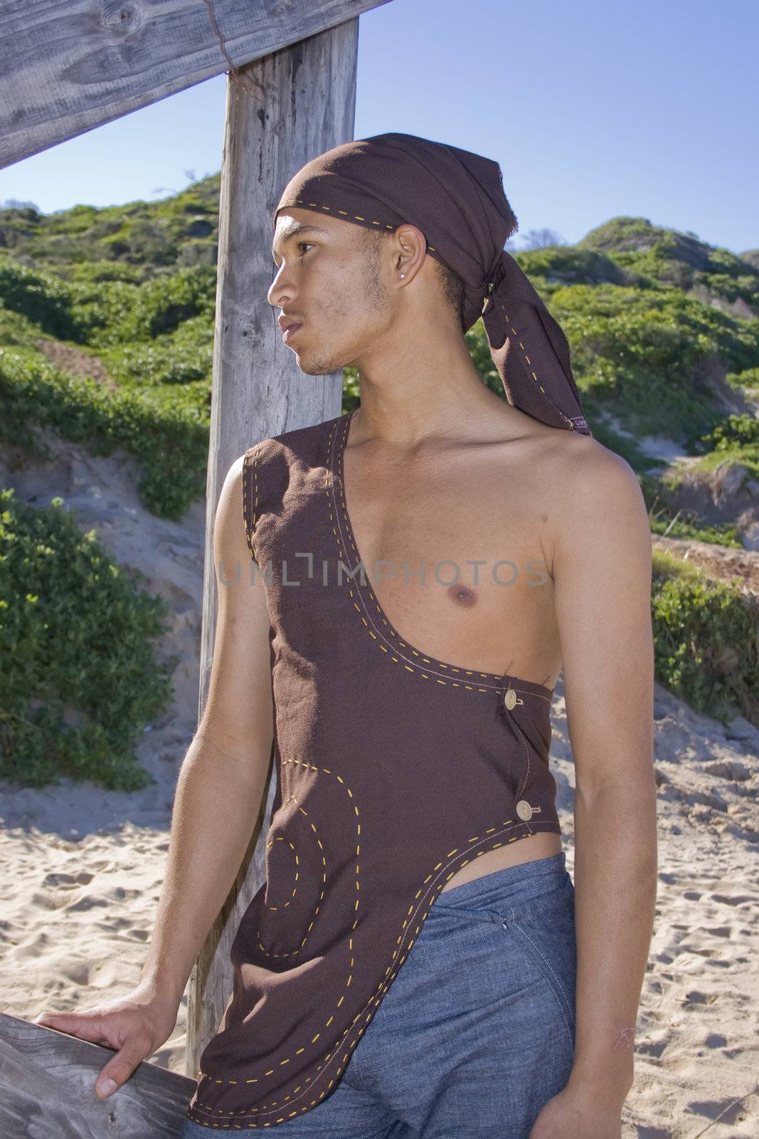 Young man dressed in rustic clothing on the beach