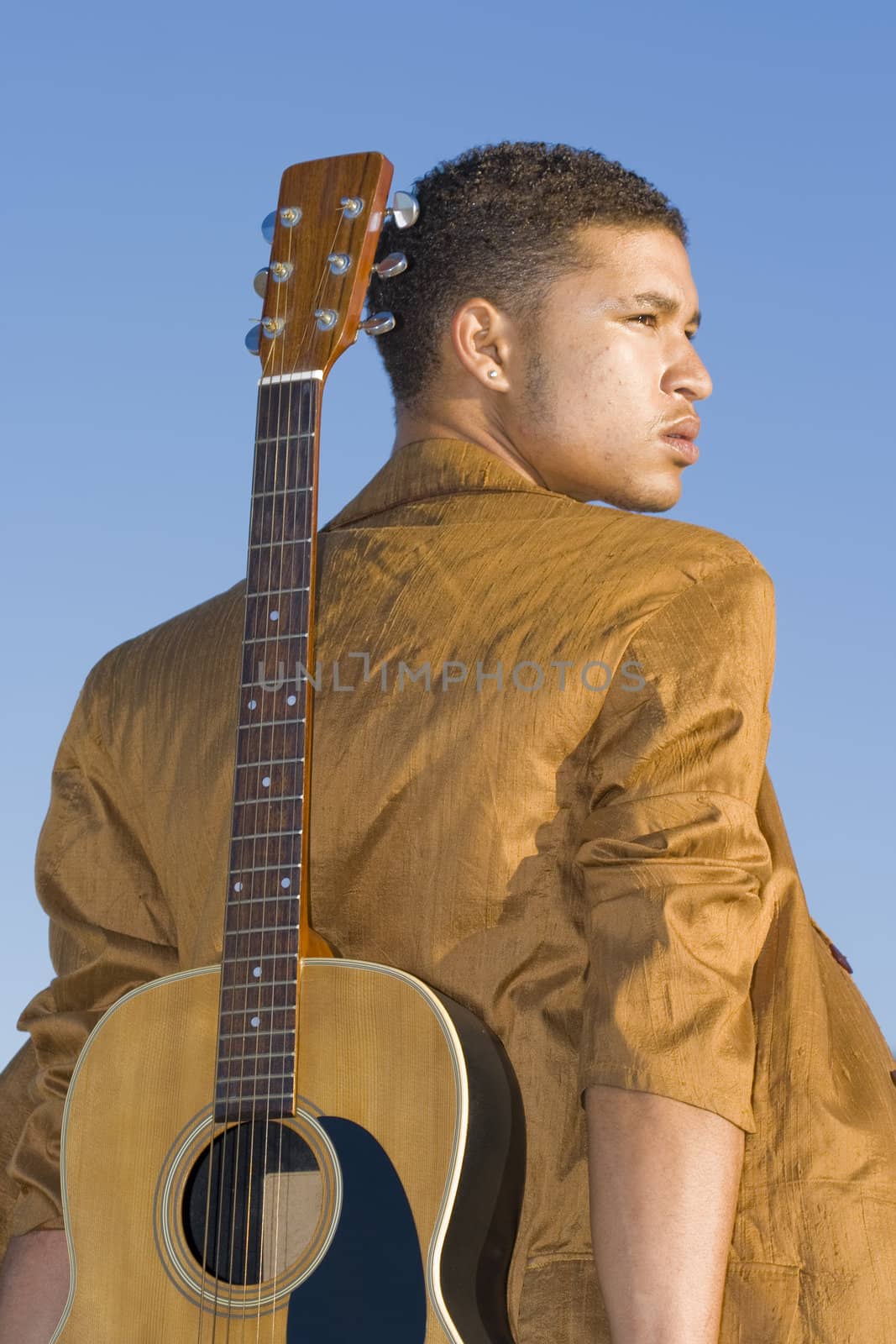 Young man with his guitar on his back