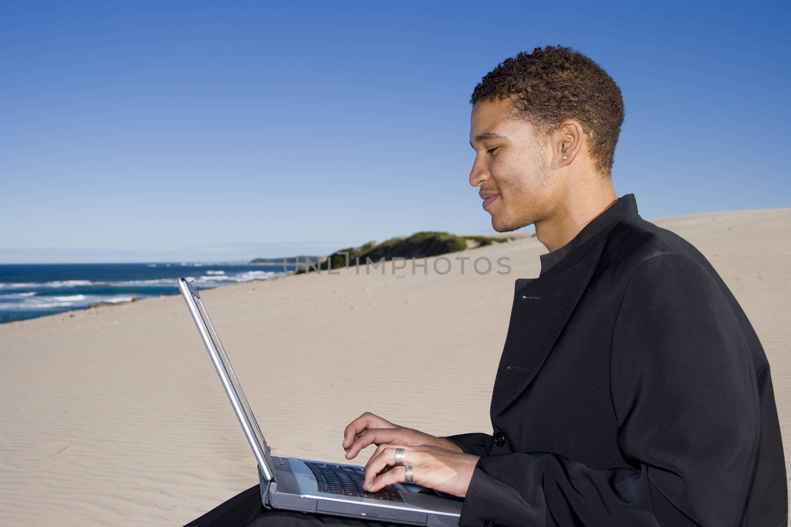 Young professional working on a laptop at the beach