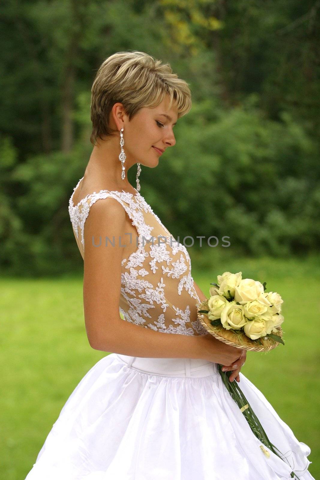 Beautiful the bride with a bouquet in park