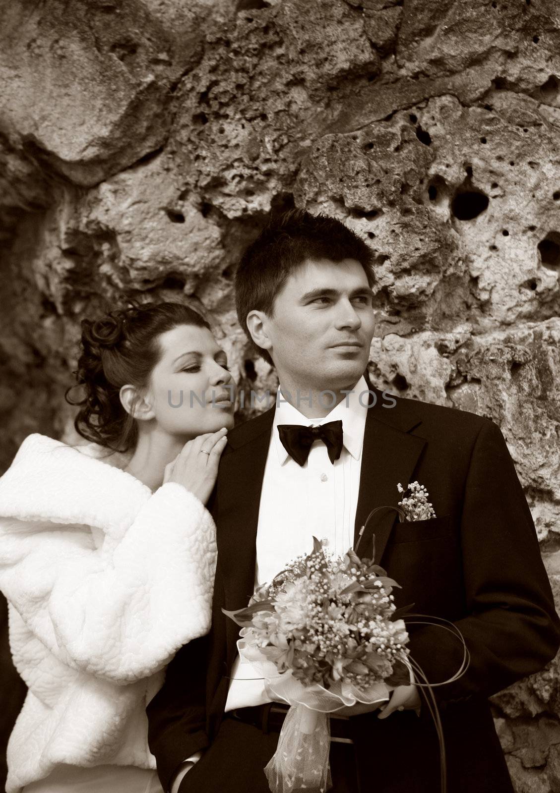 Recently married pair on a background of a stone. b/w+sepia