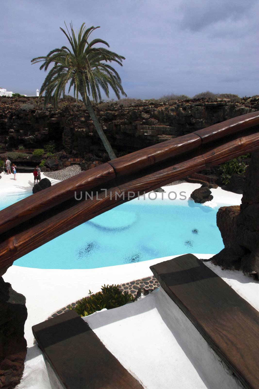 couples walk hand in hand by the pool