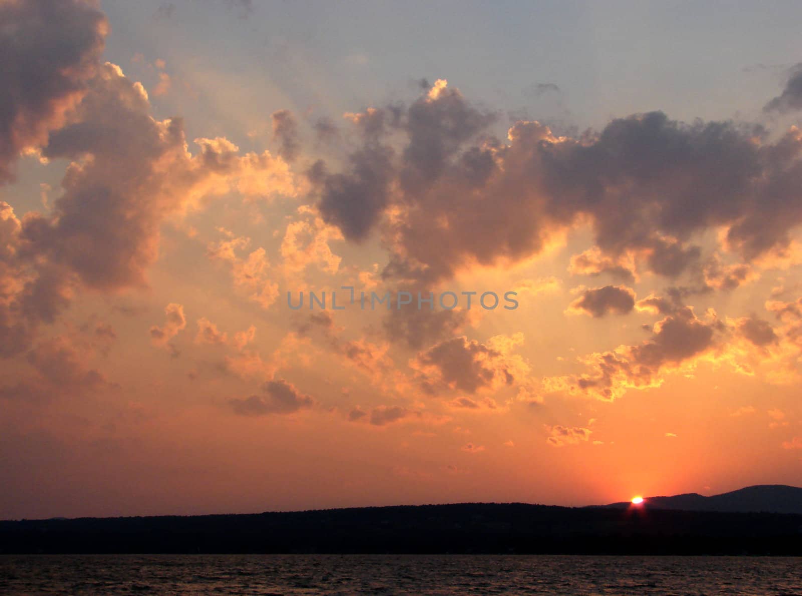 Sun-rays through the clouds in the sky at sunset