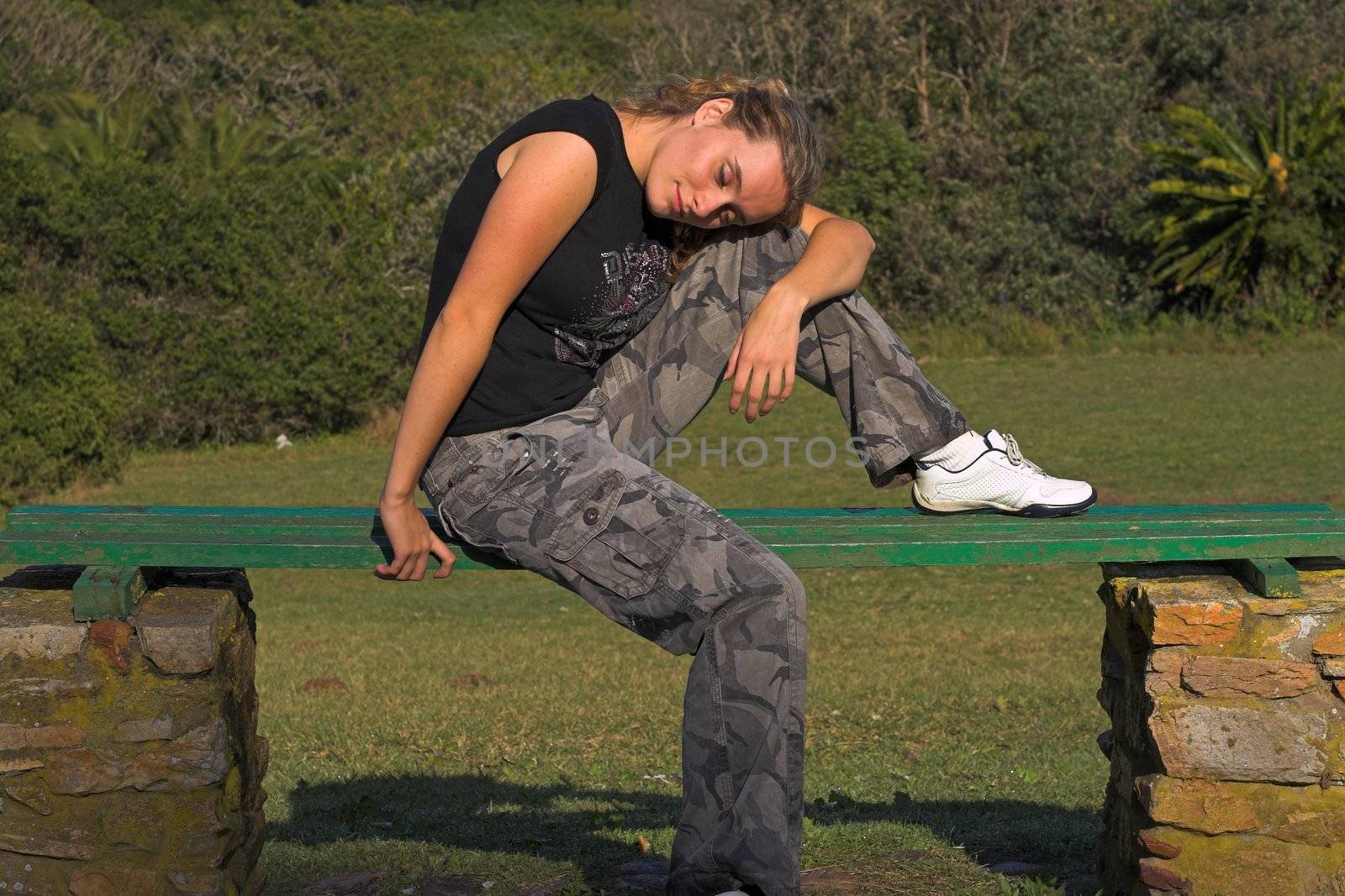Sexy girl sitting on a bench dreaming