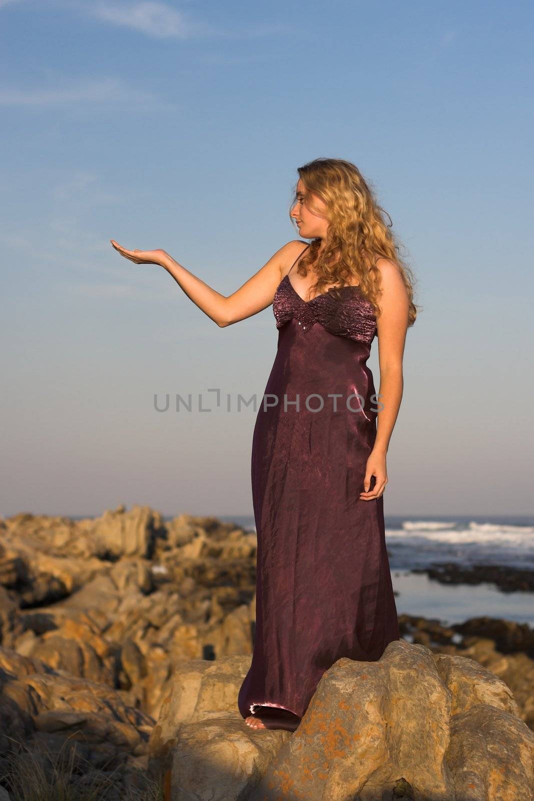 Girl in purple dress holding one arm up