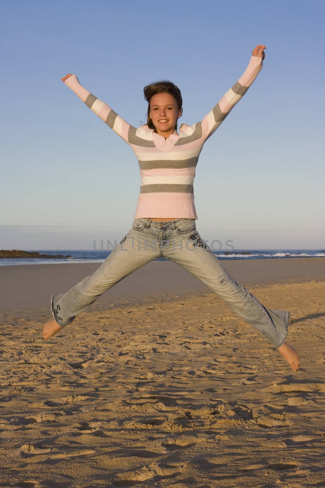 Young girl jumping into the air, with arms outstretched