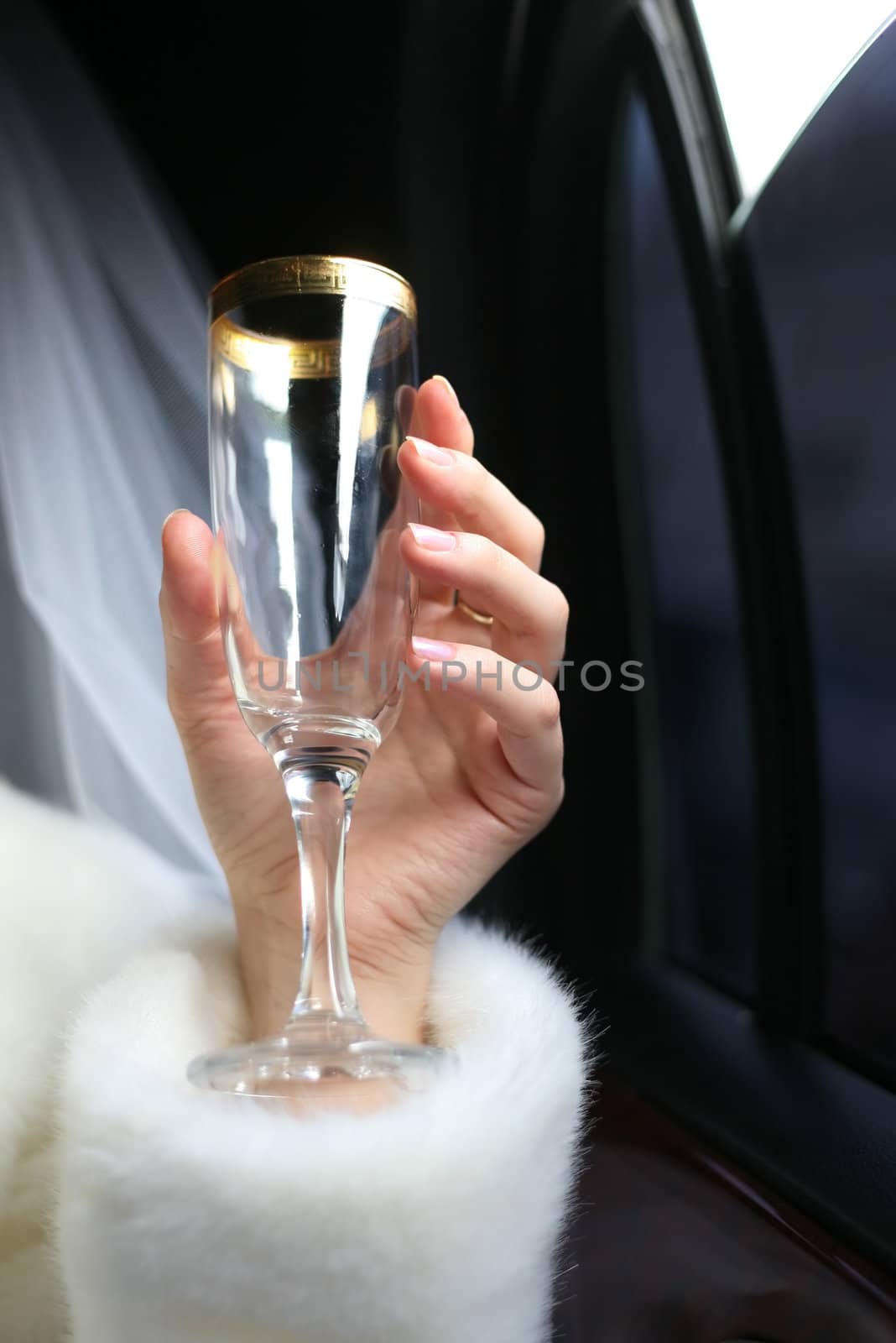 Glass with champagne in a hand of the bride