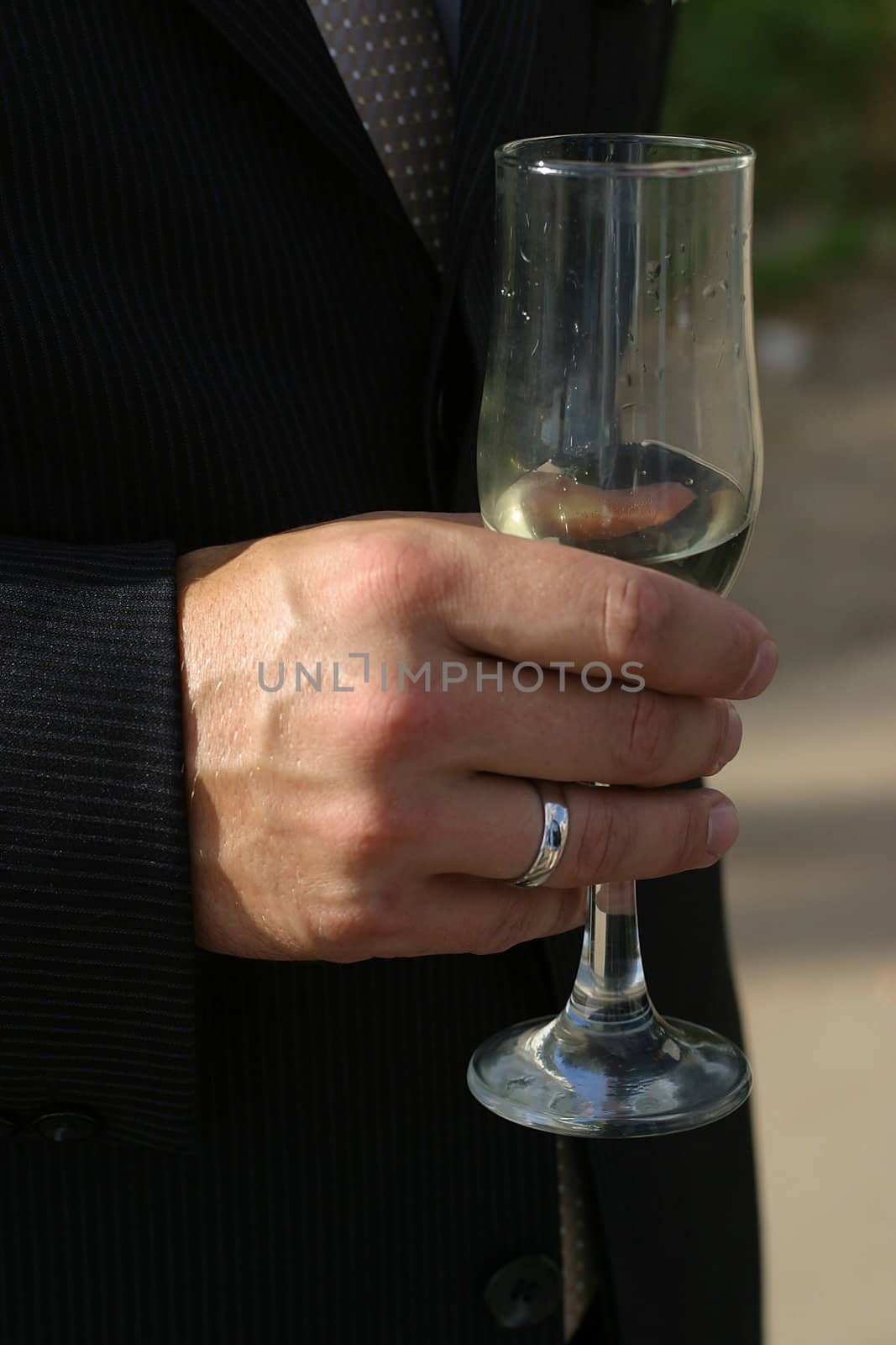 Glass of champagne in a hand of the groom