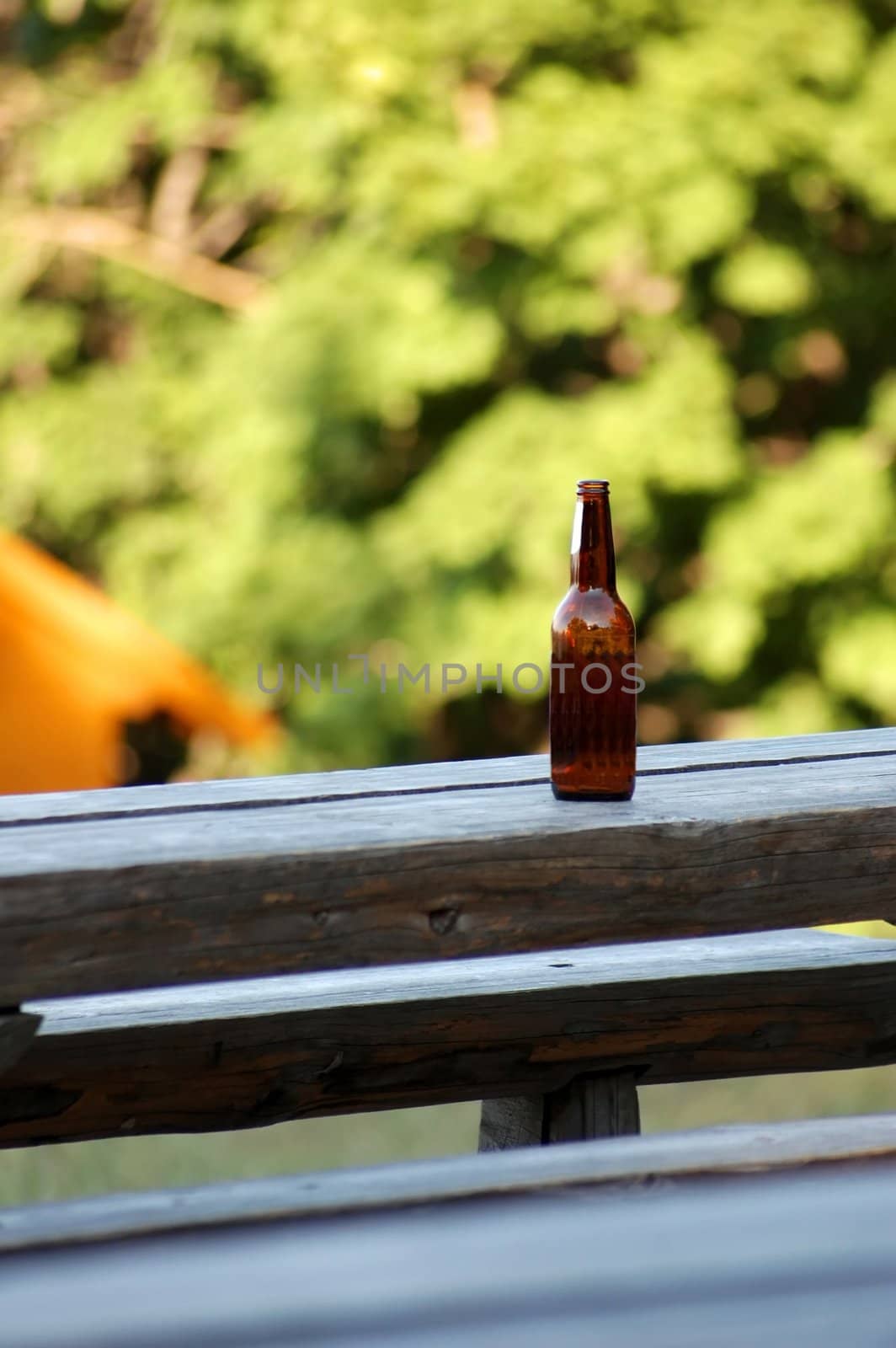 brown bottle on the bench in mountains