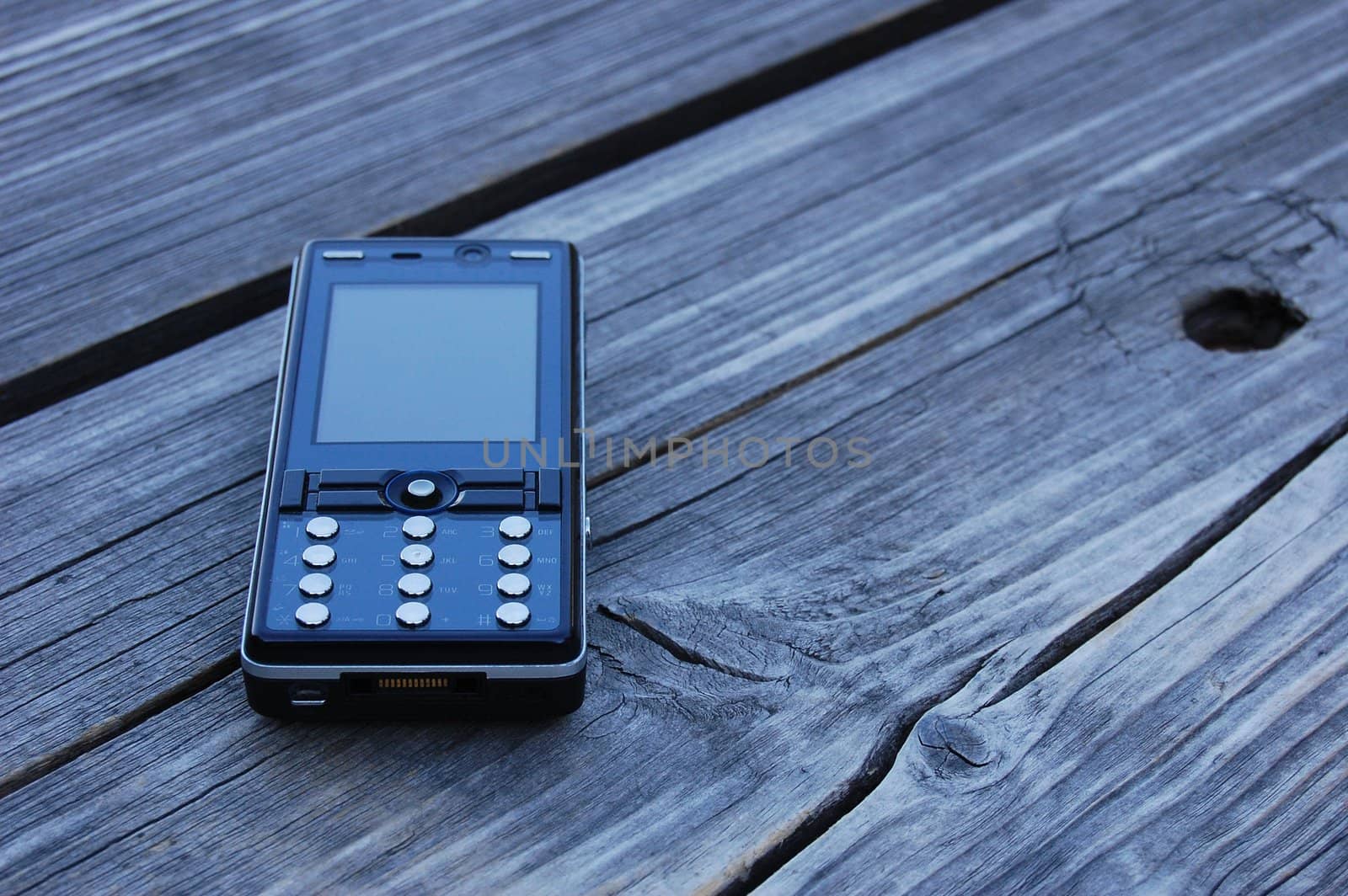 black mobile phone lying on the bench by Gandalfo