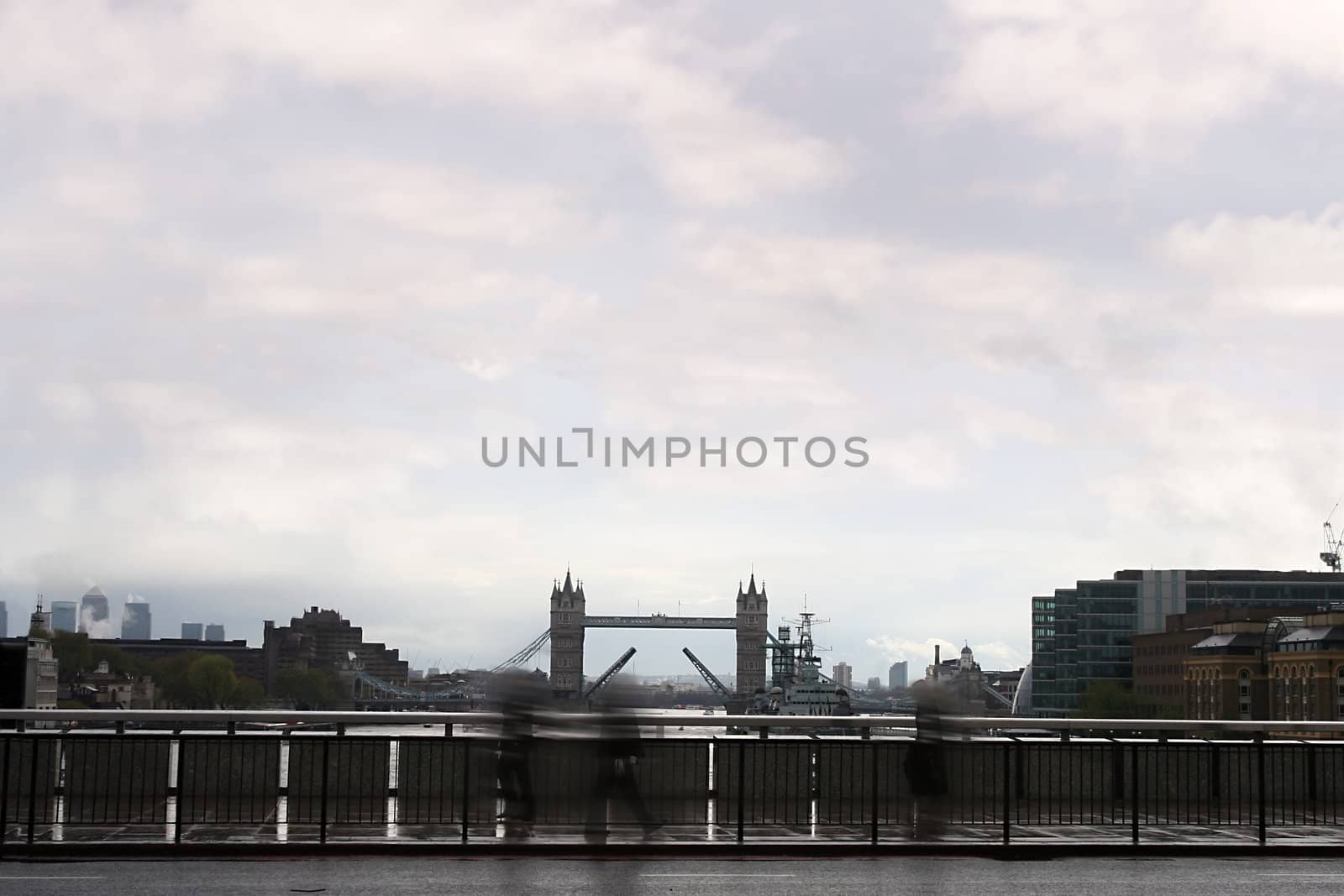 people passing over a bridge in london city on there way to work.