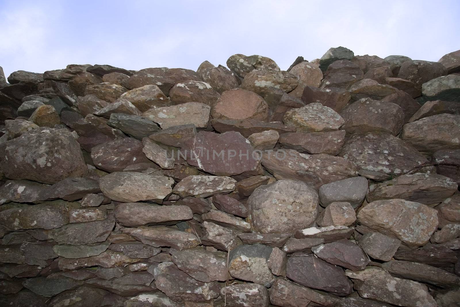 an old irish dry stone wall against a sky background