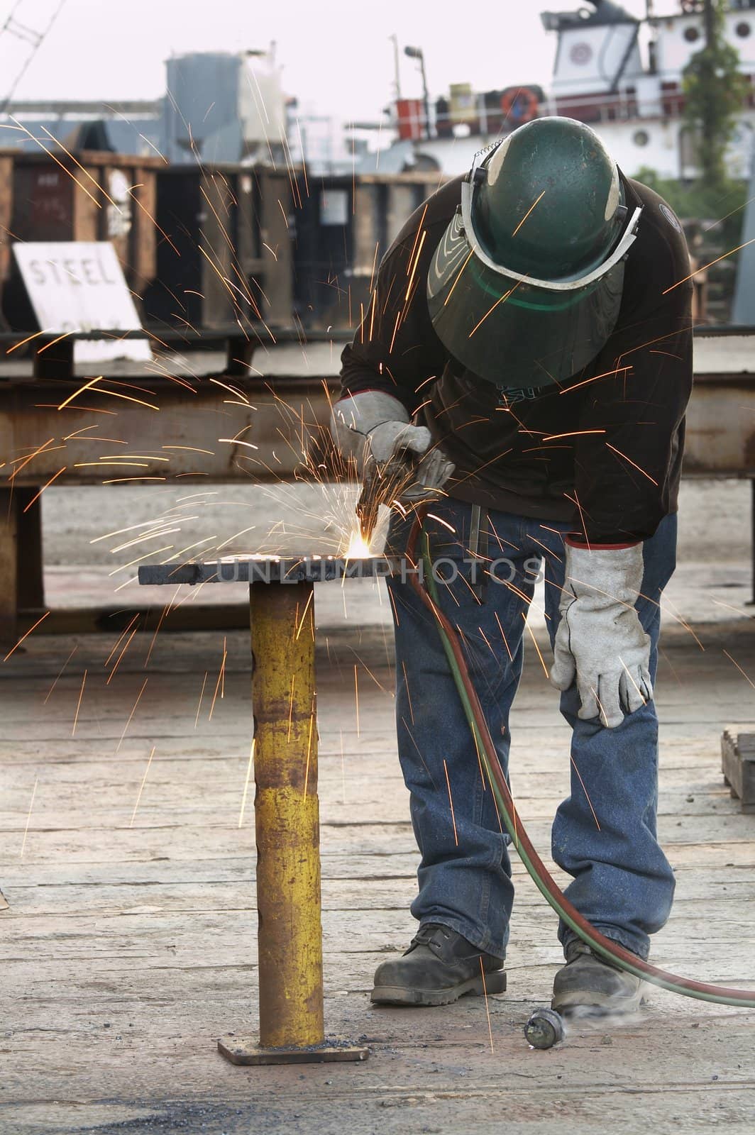 a welder working a torch at shipyard