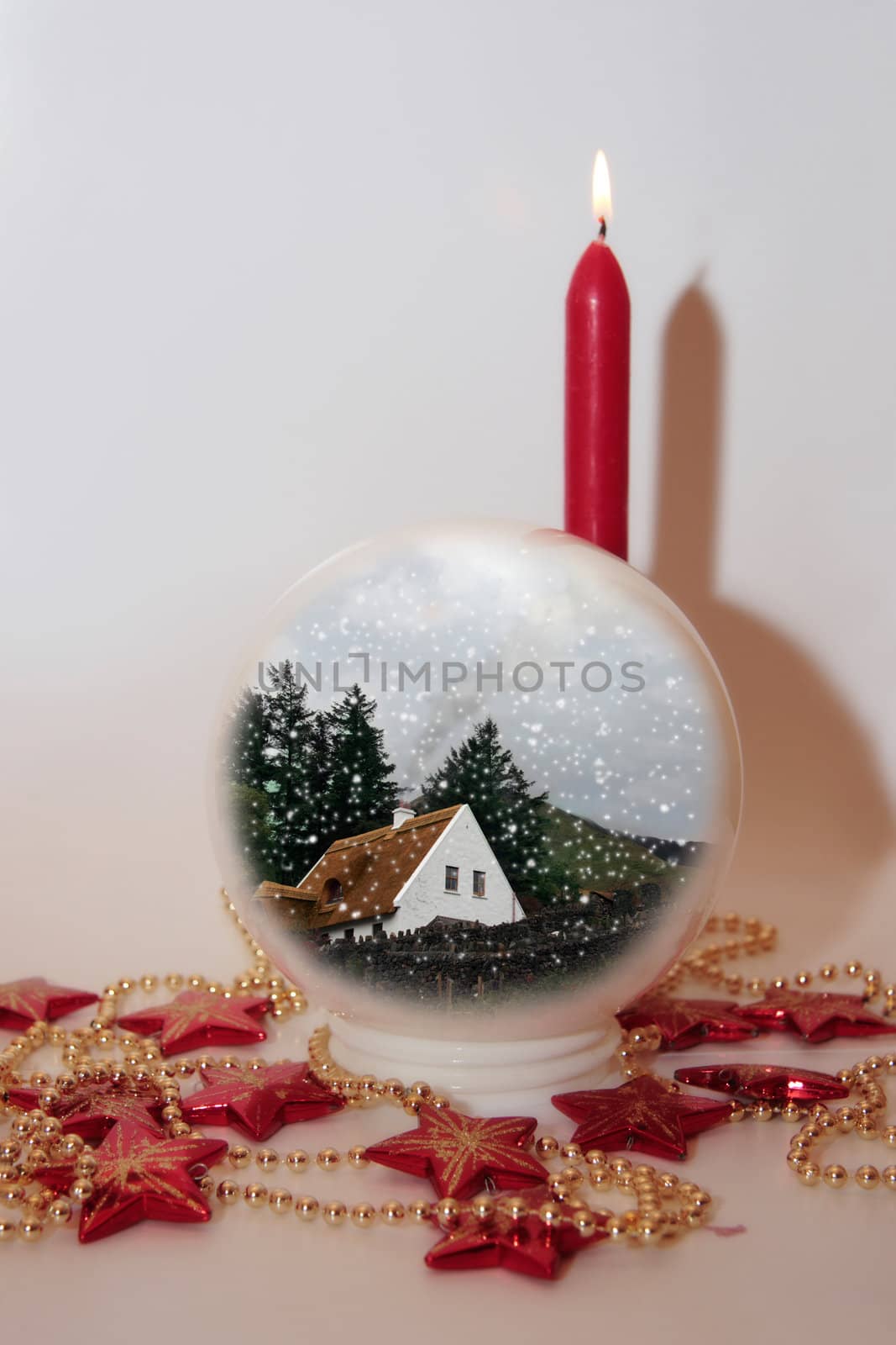 christmas crystal ball against a snowing background with candles