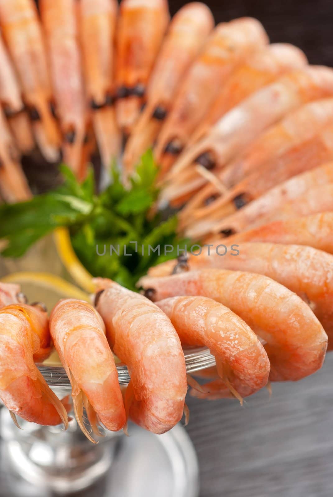 tasty shrimps with lemon and greens closeup