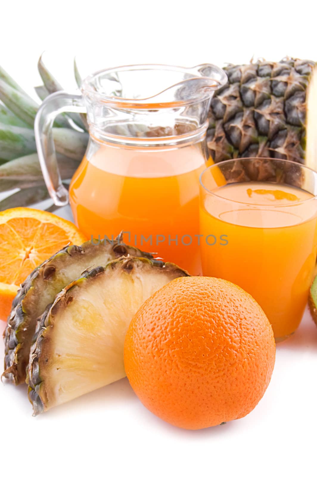 Jug and glass of multivitamin juice with ananas and orange
