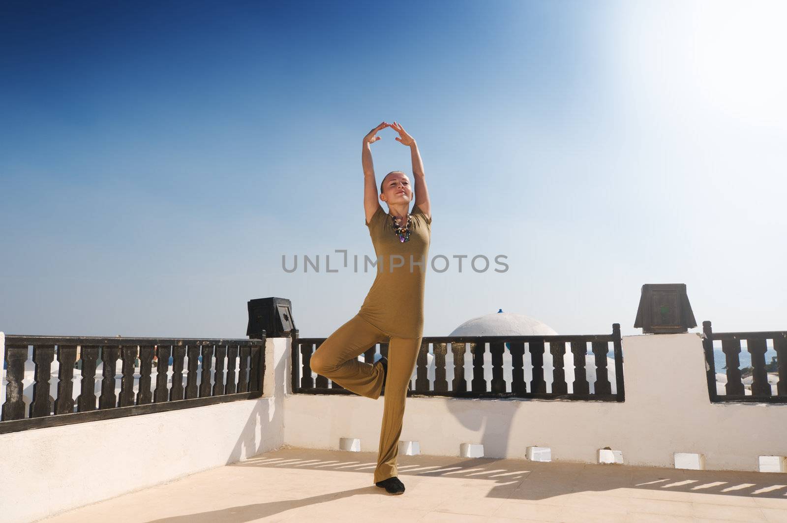 Attractive redhair woman practicing Vinyasa yoga outdoors