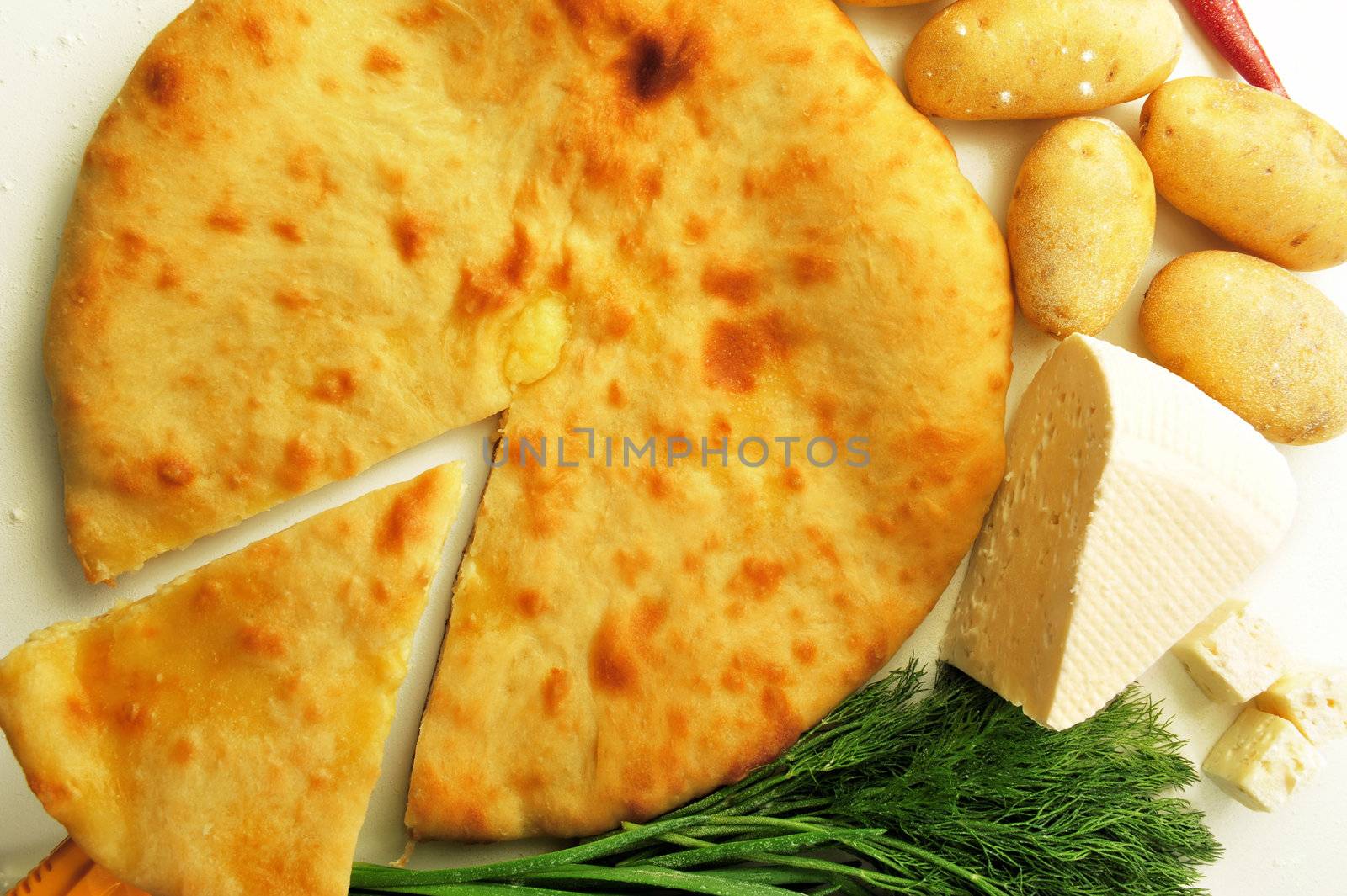 food composition made of flat cake, potato, cheese and spring onion