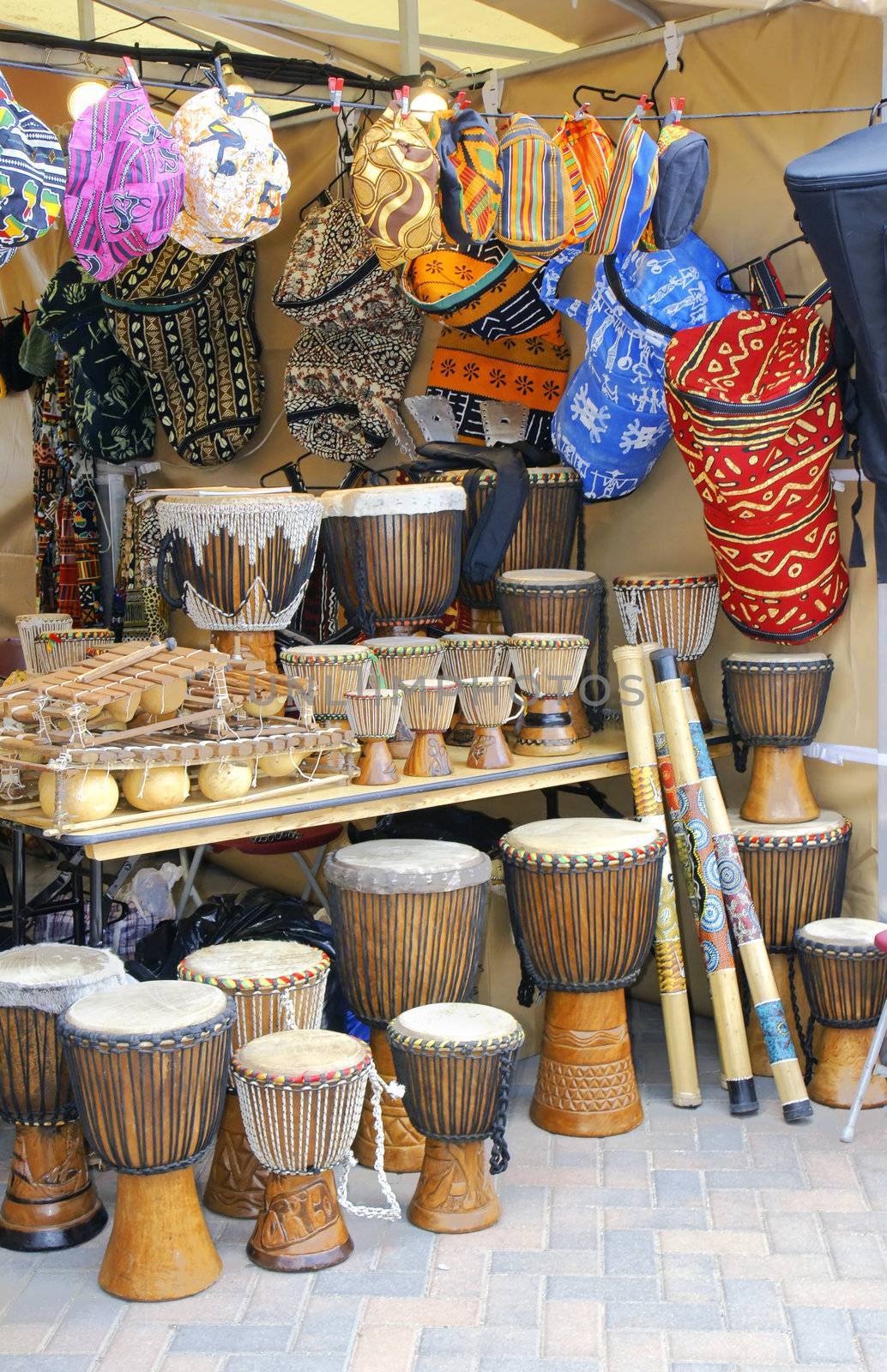 African merchant stand with djembe drums, textile and other traditional arts and crafts.