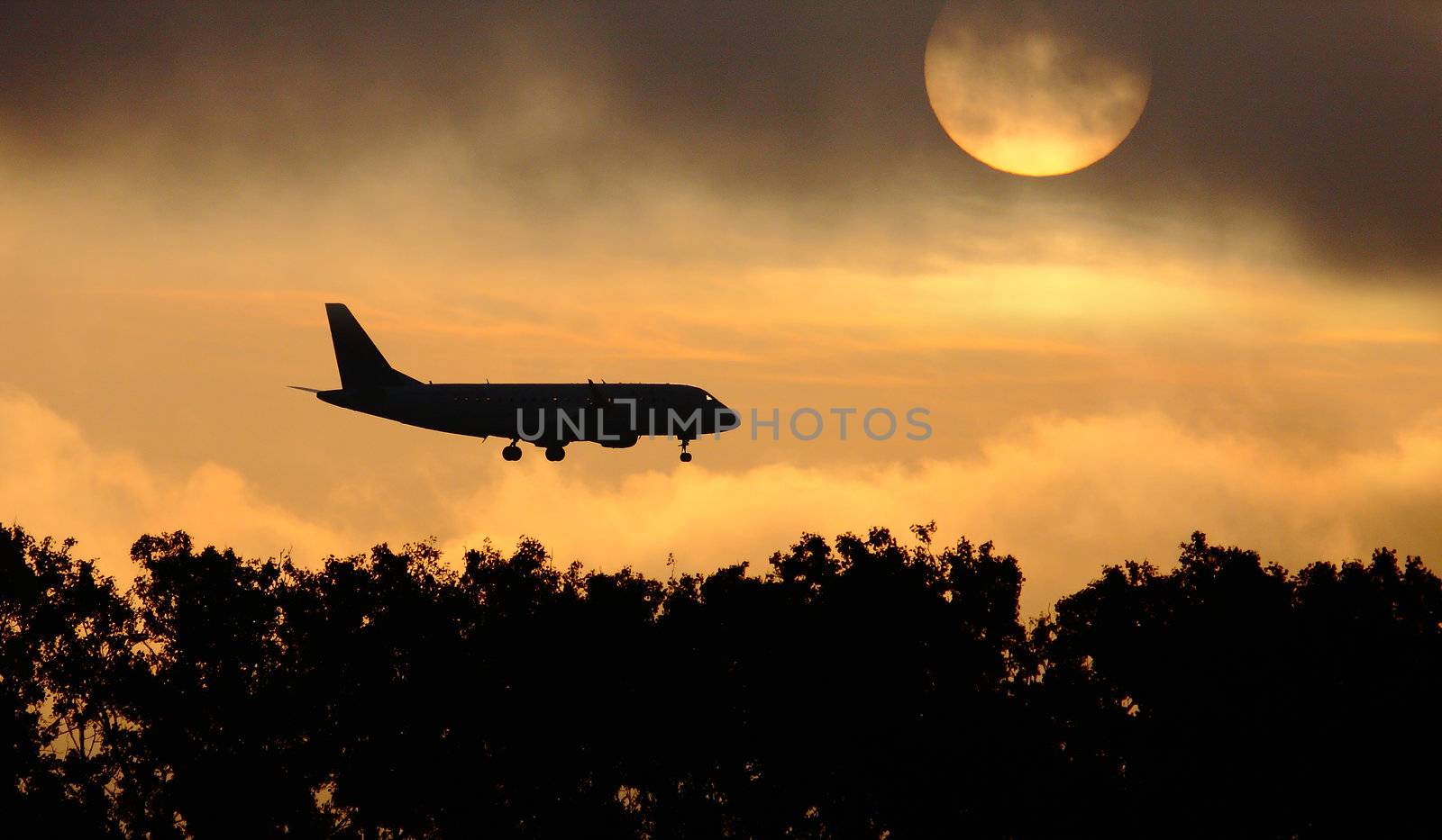 Silhouette of the big plane on a sunrise background