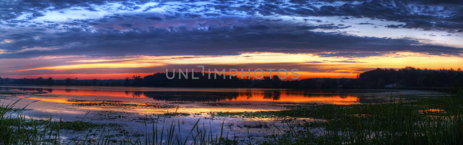 Panorama of a beautiful sunrise on a lake.