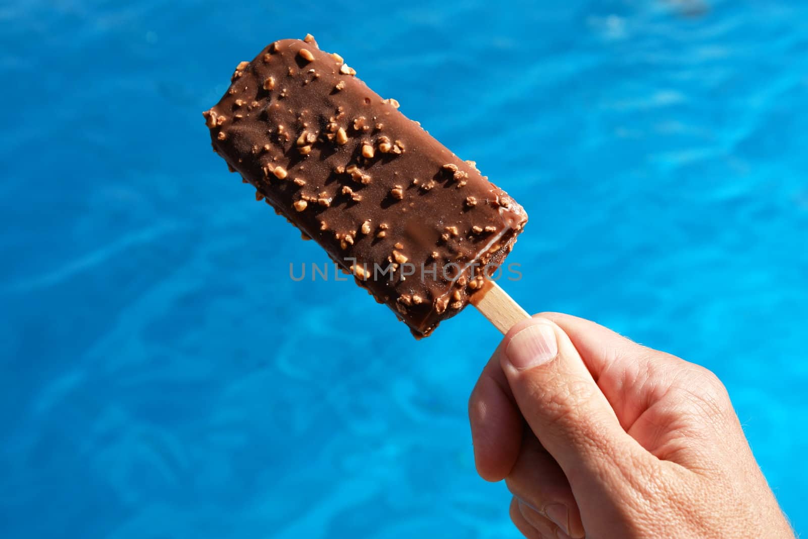 popsicle against a swimming pool on a hot day