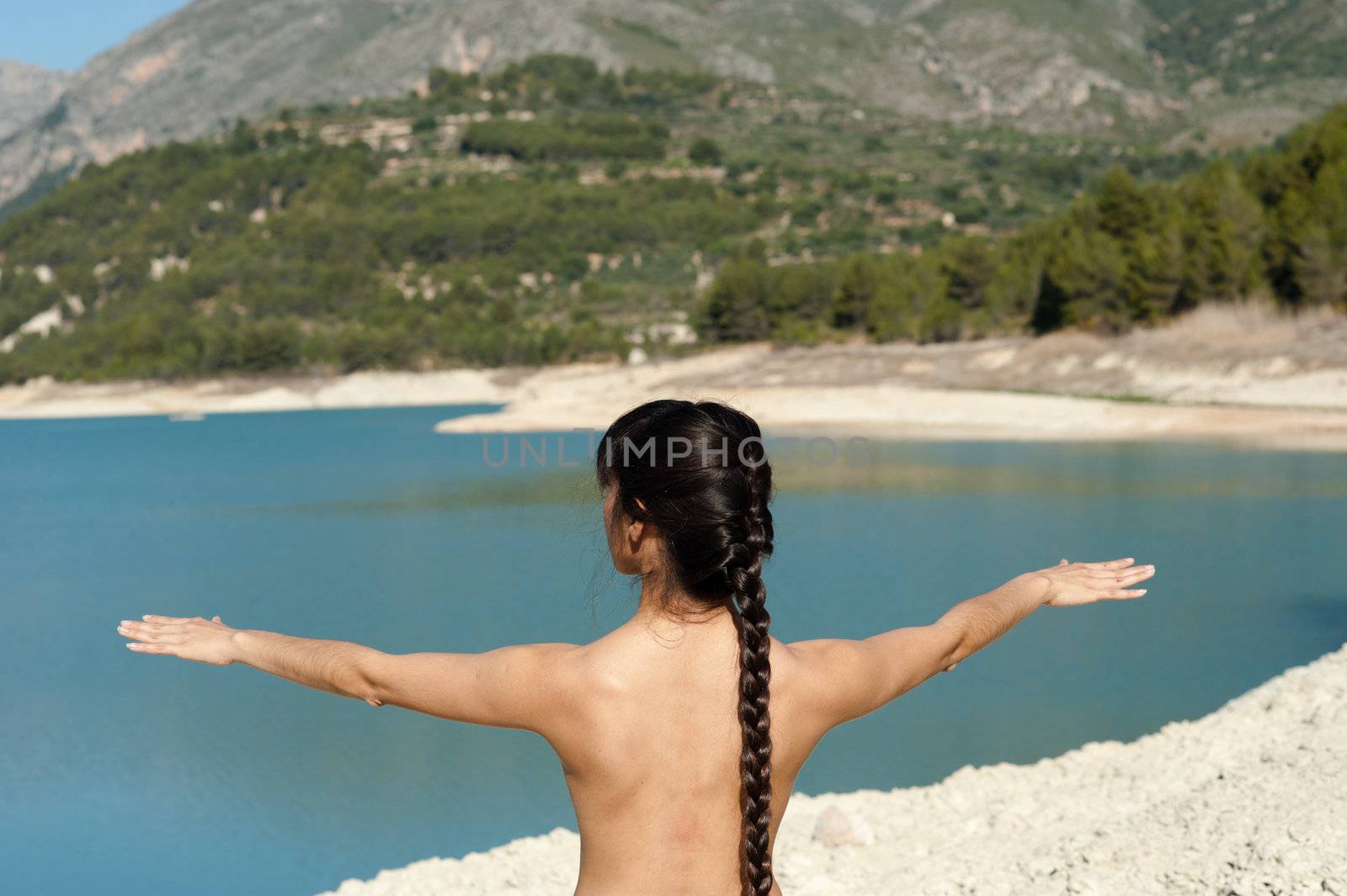 Woman enjoying early morning yoga on the shores of a lake by hemeroskopion