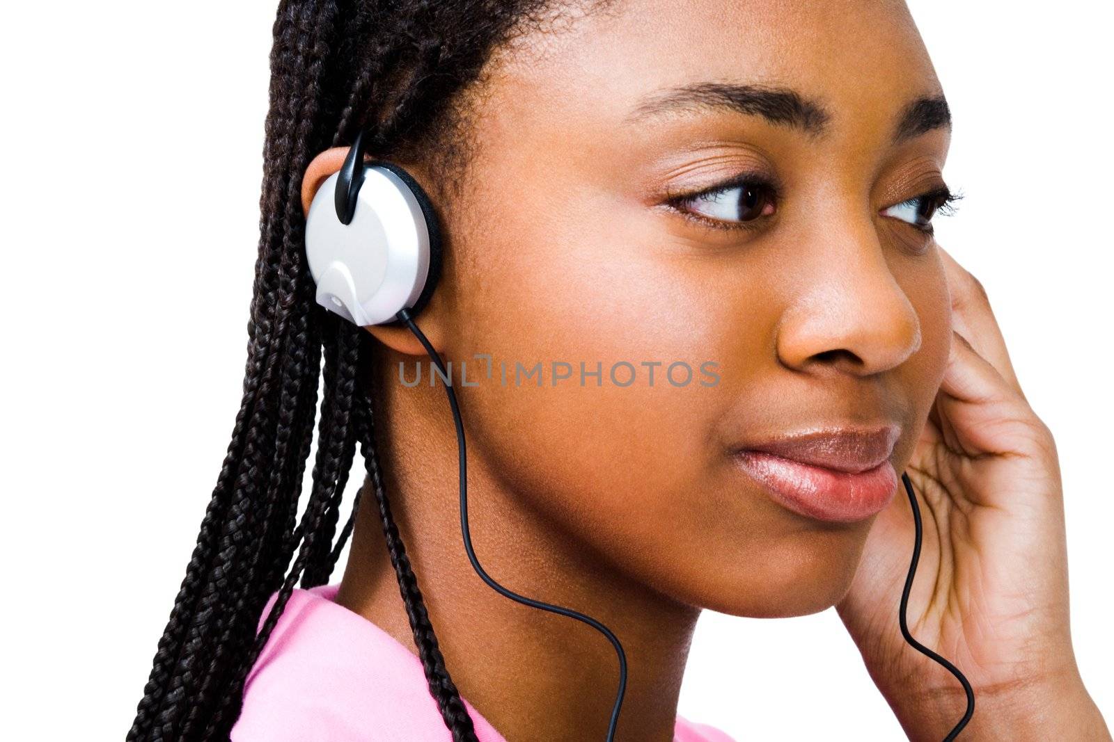 Teenage girl listening to music on headphones and smiling isolated over white