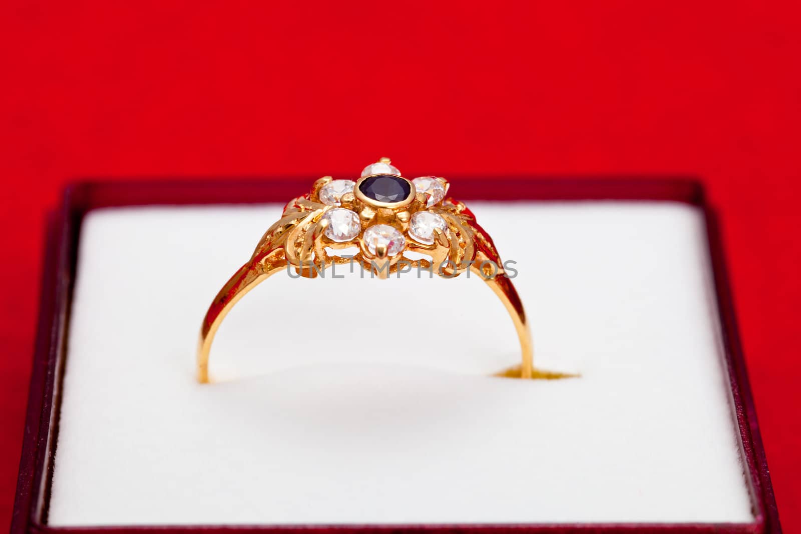 Fantastic gold ring adorned with one blue  and several white zirconia