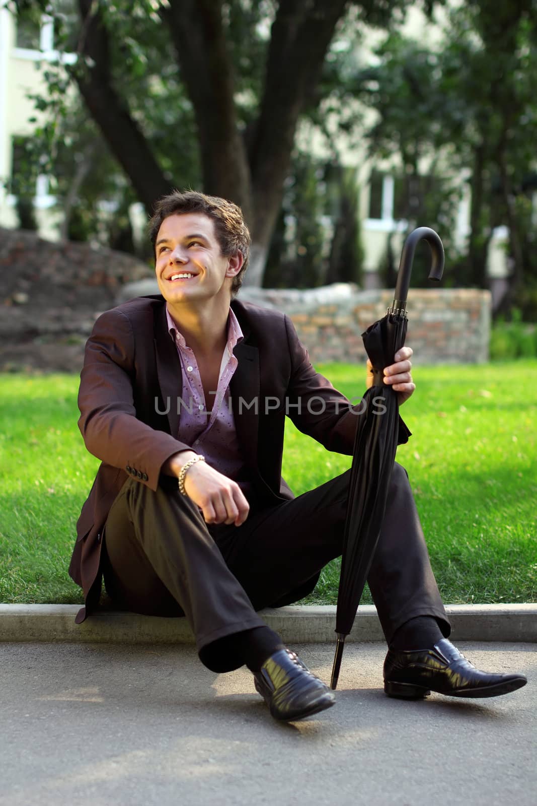 Smiling man sitting on the grass by Legioner476